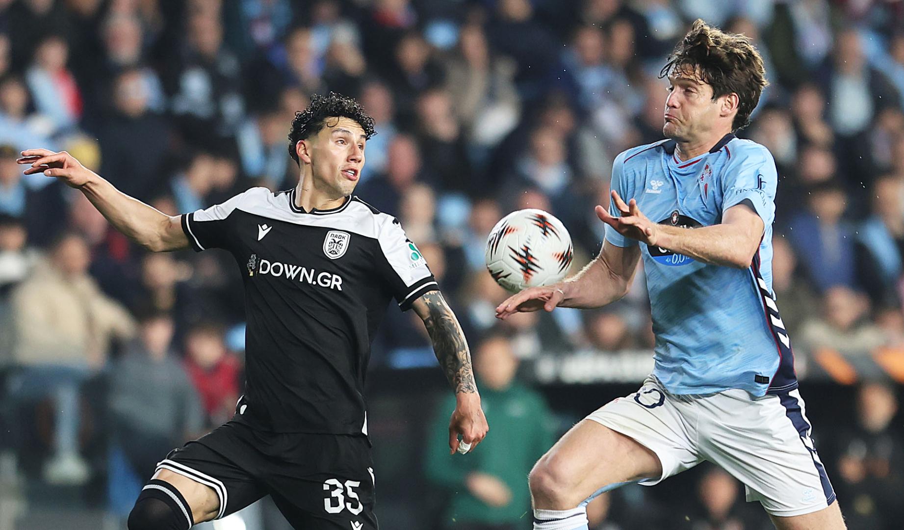El defensa del Celta Marcos Alonso pelea un balón con Jorge Sánchez, del PAOK