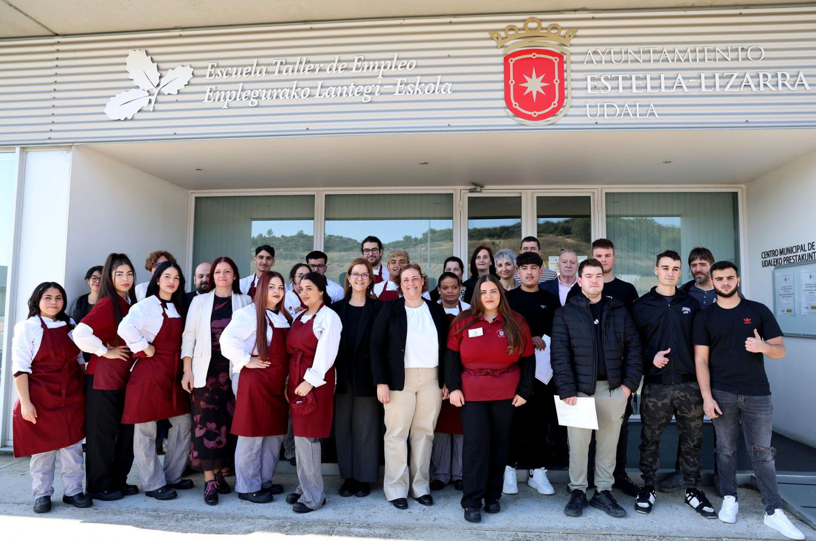 Alumnos, profesores y representantes institucionales en el exterior de la escuela taller de Estella tras la clausura