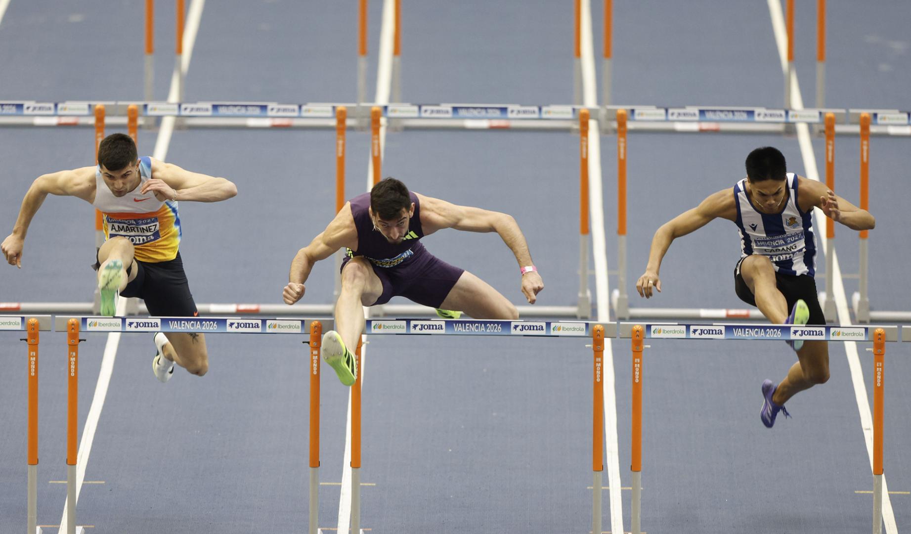 El atleta Enrique Llopis (c) se impone a Asier Martínez (i), segundo clasificado, y a John Cabang (d), tercero, en la final de 60m Vallas Hombres de los Campeonatos de España de Atletismo en pista cubierta que se han disputado en el Palacio Velódromo Luis Piug de Valencia, este fin de semana.