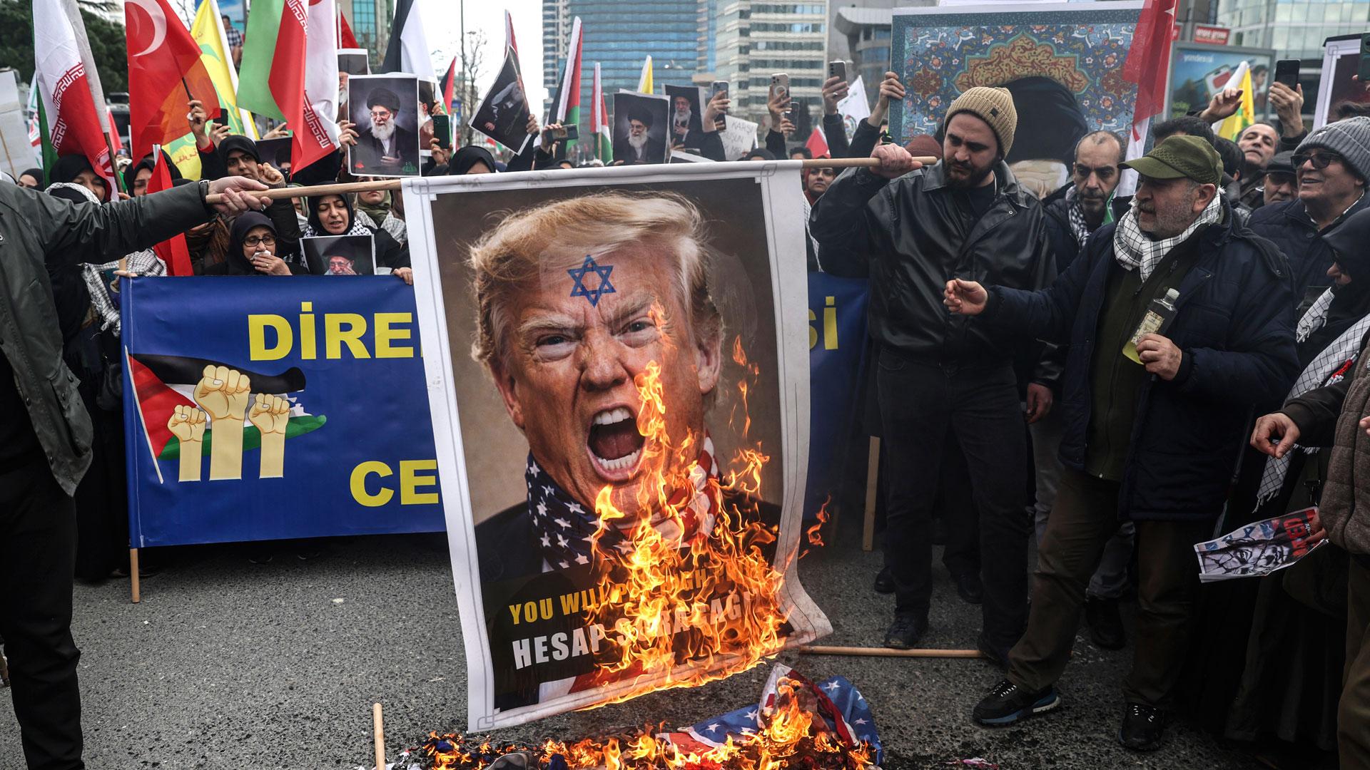 Manifestantes queman una pancarta con el rostro del presidente estadounidense Donald Trump, en una protesta contra los ataques en Estambul