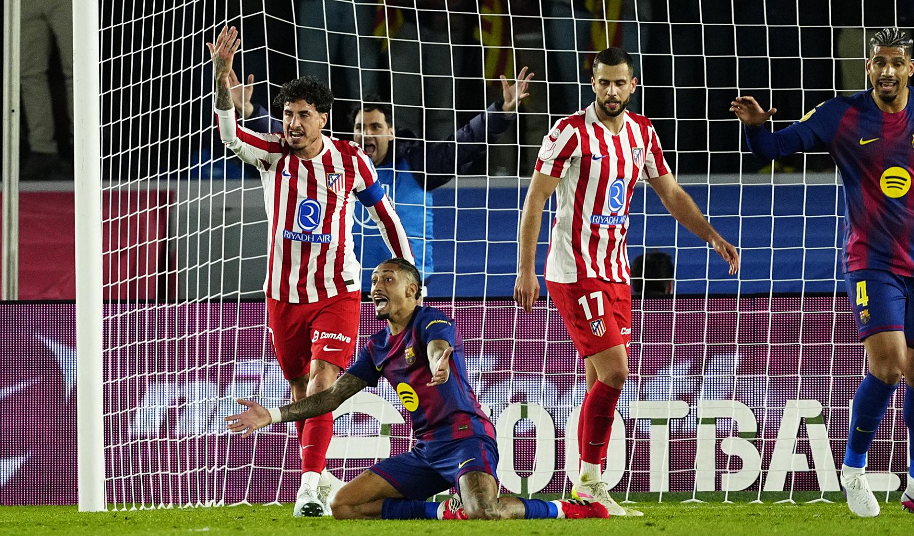 El delantero del Barcelona Raphina reclama una falta ante José María Giménez, del Atlético