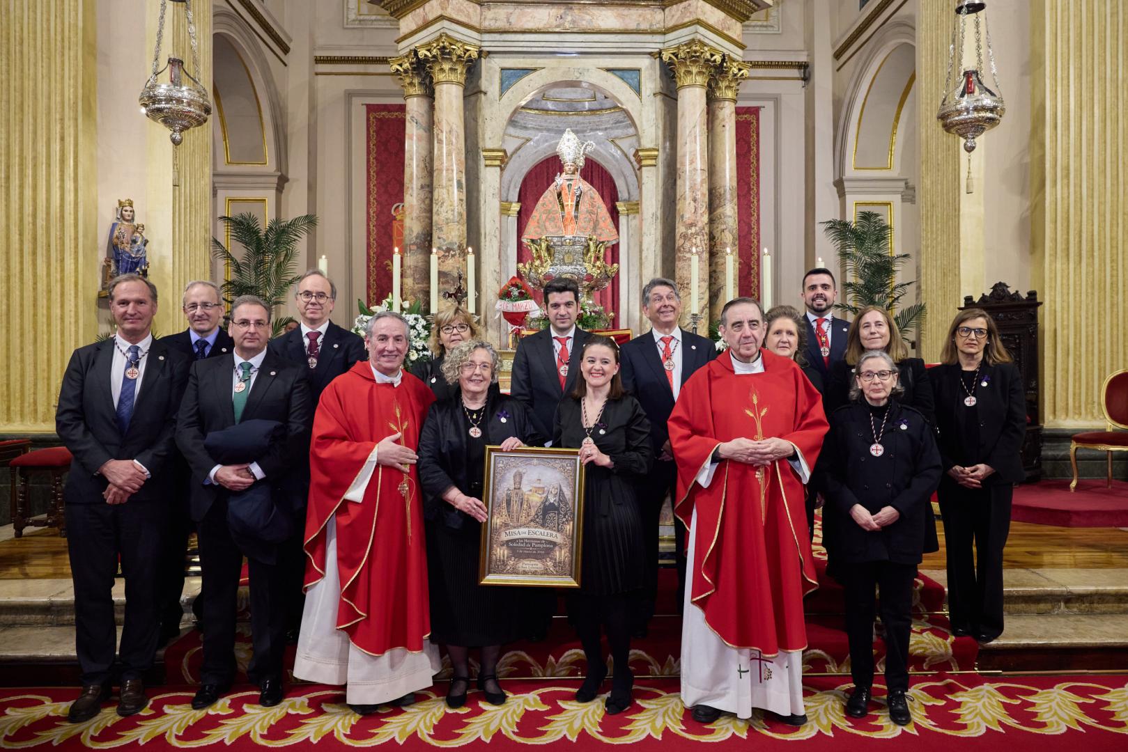 La priora Marimar Ganuza y Neus Vives sostienen el lienzo que regaló la parroquia a las Hermanas de la Soledad, el puente entre San Fermín y la Dolorosa. Con ellas, el párroco de San Lorenzo, Javier Leoz; Juan Luis Lorda, capellán de la Hermandad de la Pasión y la junta de la institución.
