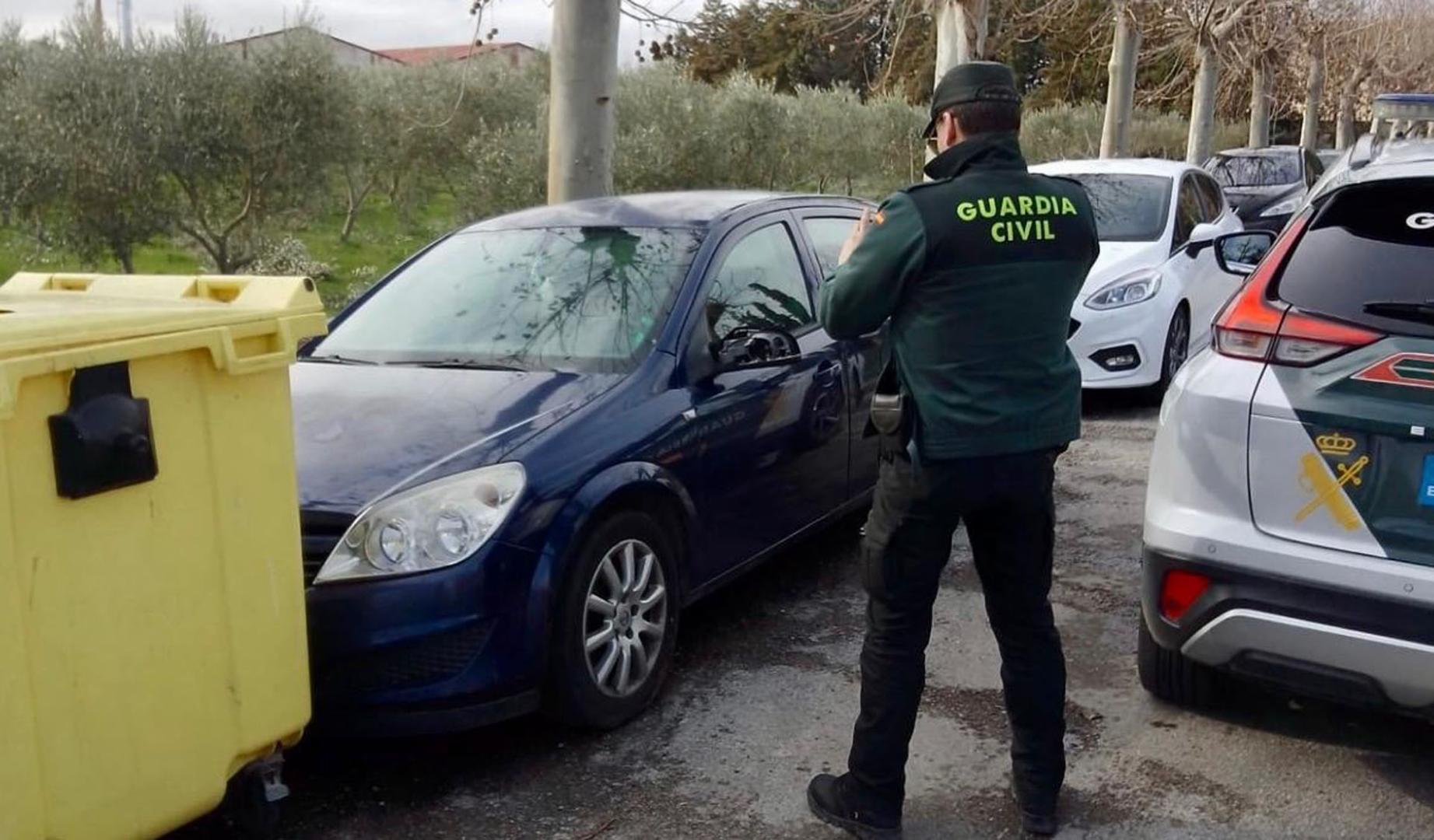 Un agente de la Guardia Civil fotografía uno de los vehículos dañados