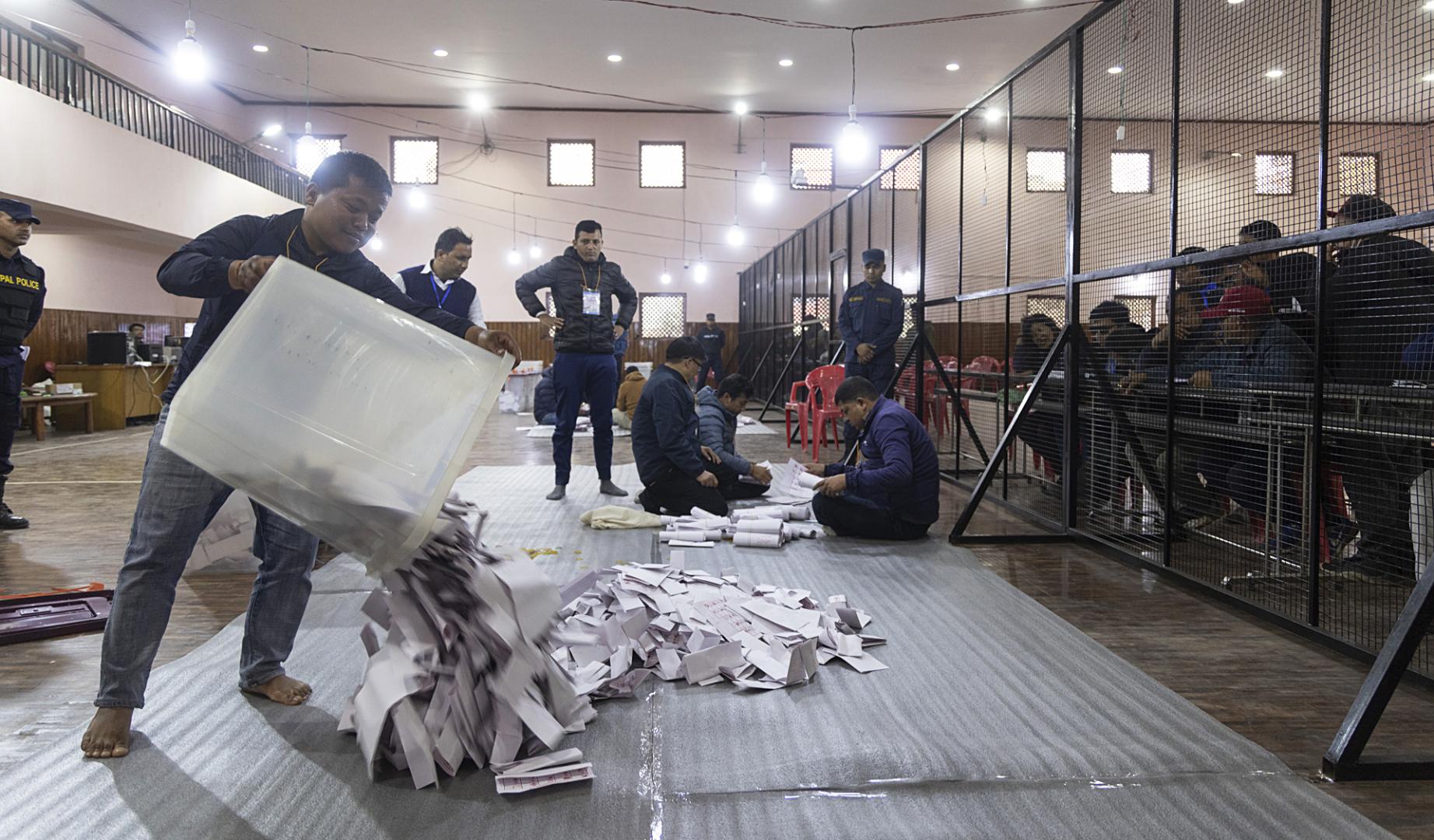 Varias personas proceden a realizar el recuento de votos en un colegio electoral de Katmandú