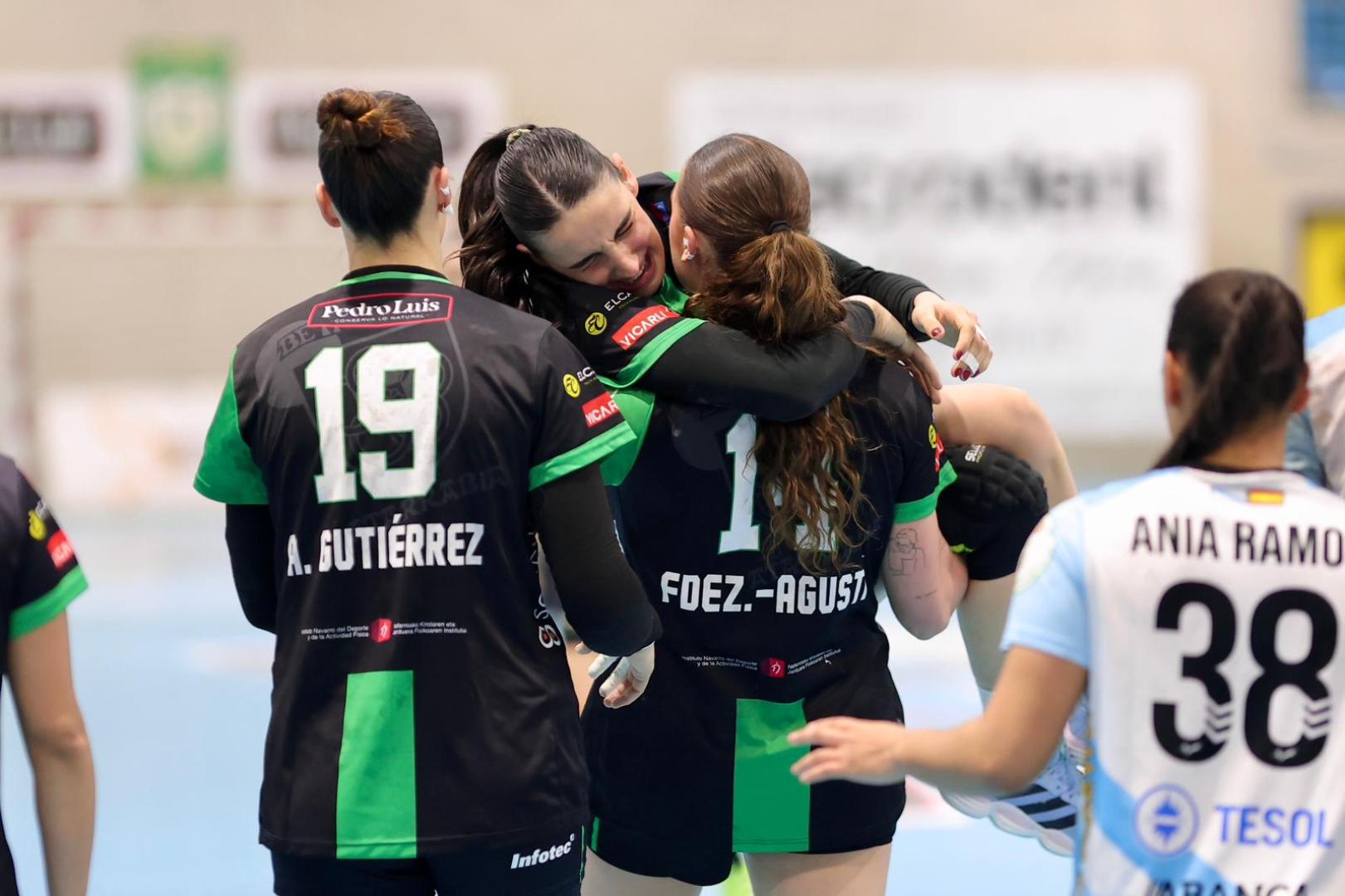 Maialen Orbañanos, con gesto de dolor, en brazos de Isi tras lesionarse la rodilla izquierda en los primeros segundos del encuentro