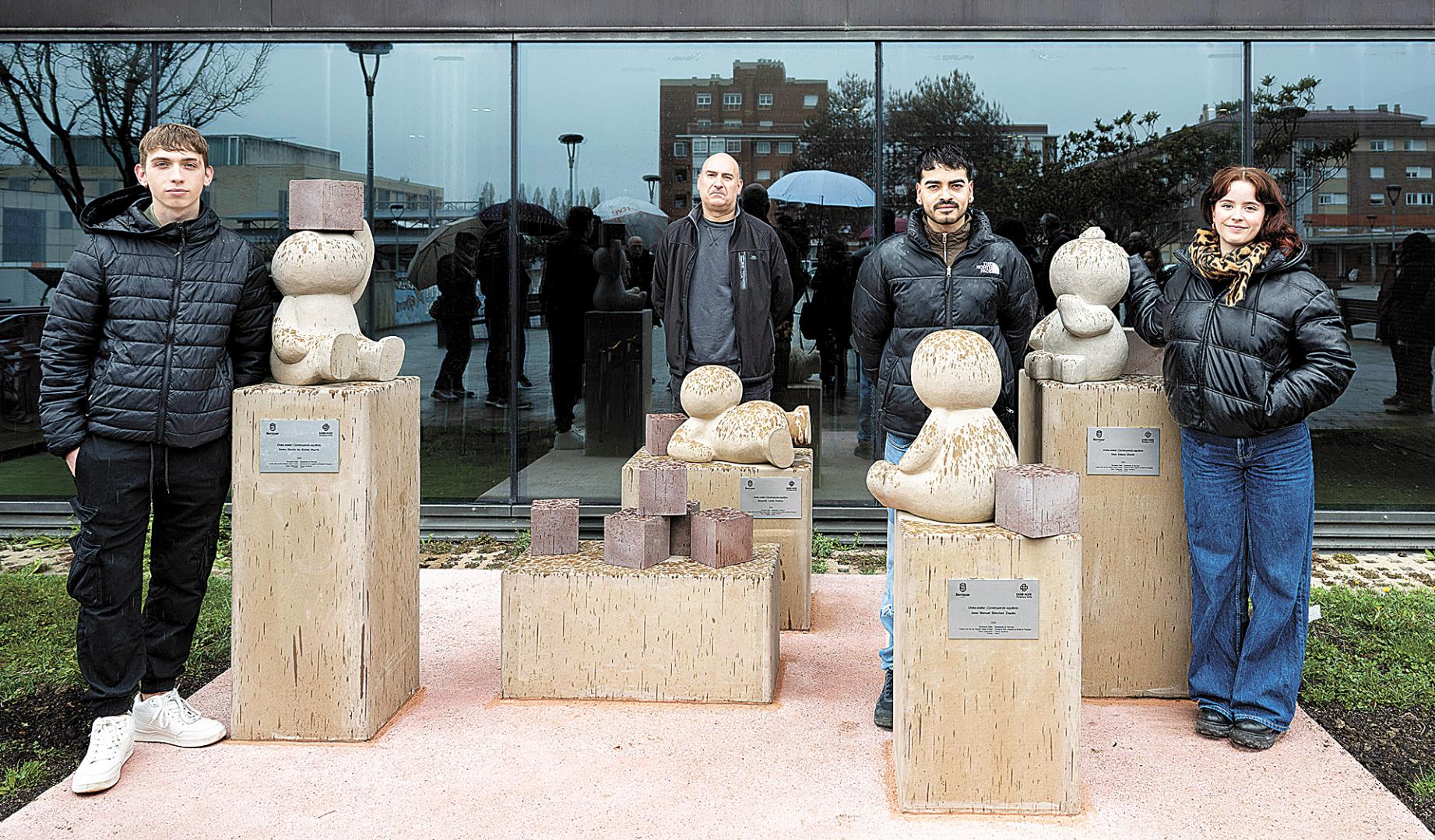 Gorka García de Eulate Huarte, Benjamín Landa Ramírez, José Manuel Sánchez Zapata y Naia Eslava Chivite posan con la obra Construyendo equilibrio/Oreka eraikiz ante el Ayuntamiento de Berriozar