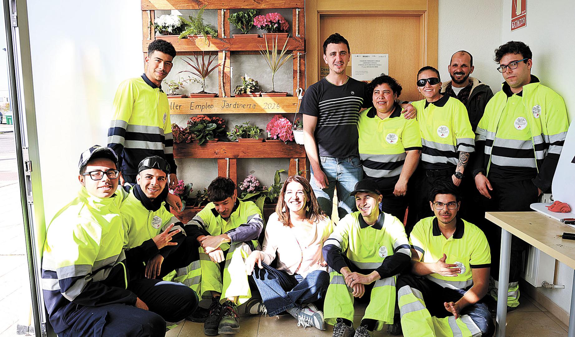 El alumnado del taller de empleo, con los responsables, y el jardín vertical que prepararon