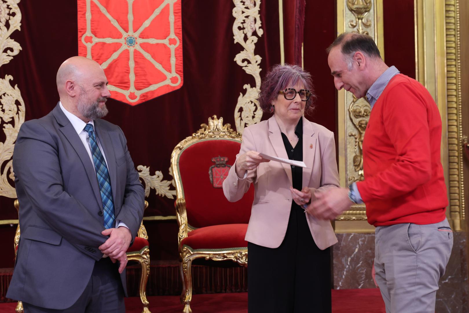La consejera Rebeca Esnaola entrega a Eduardo Salvador Castiella el certificado que reconoce la donación realizada por su madre del fondo personal de Fernando Redón y, a la izquierda, el consejero José Luis Arasti