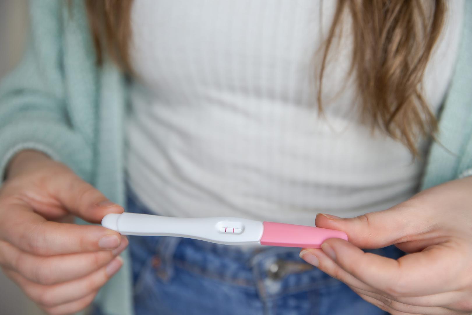 Una mujer sostiene un test de embarazo