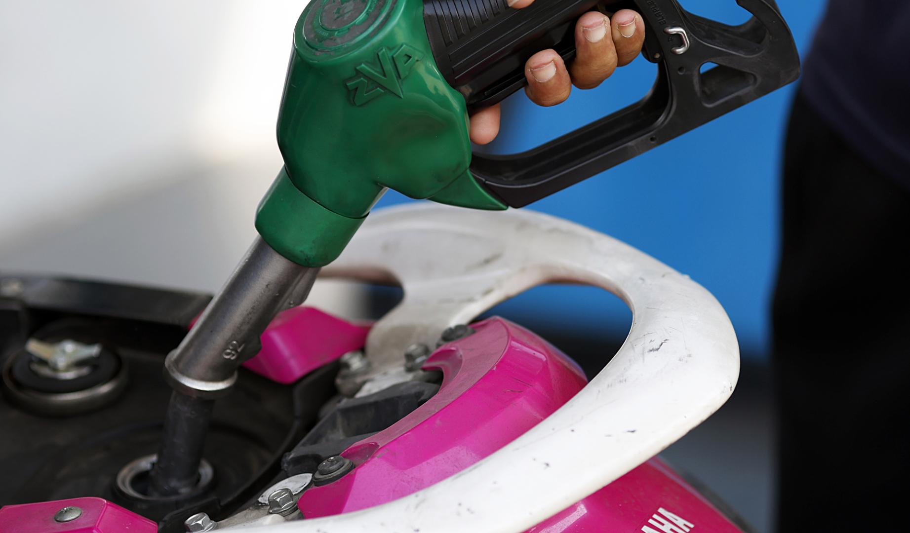 Una persona echa gasolina en el depósito de su motocicleta