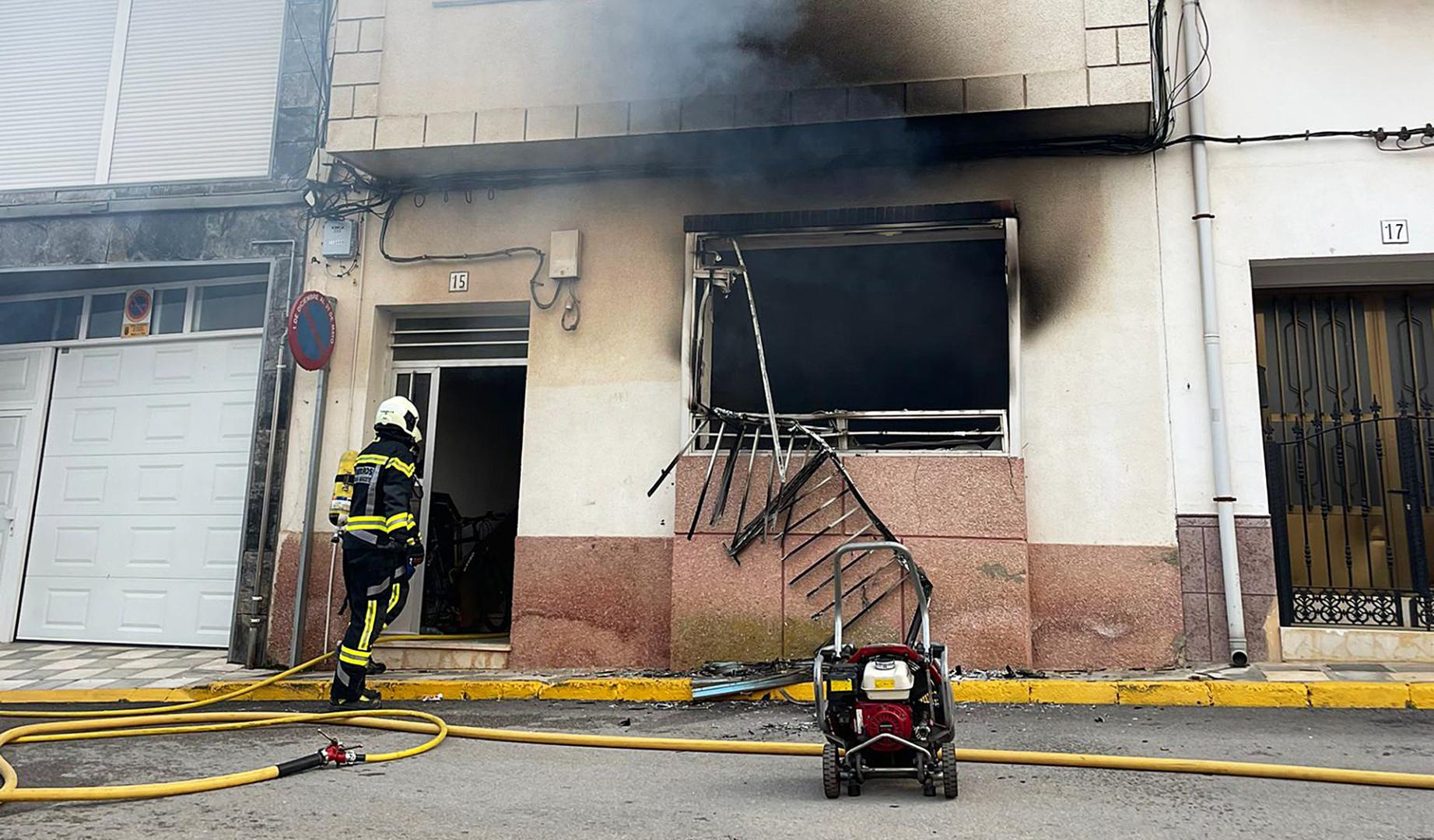 Un bombero realiza las labores de remate de la extinción del fuego en la vivienda afectada