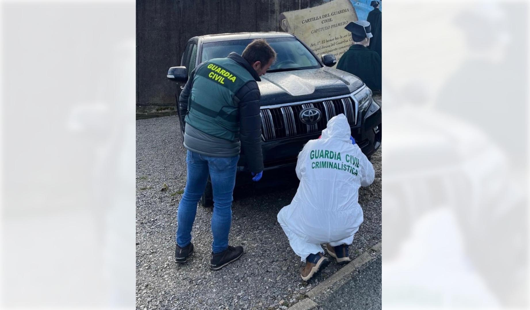 Dos guardias civiles examinan uno de los coches robados