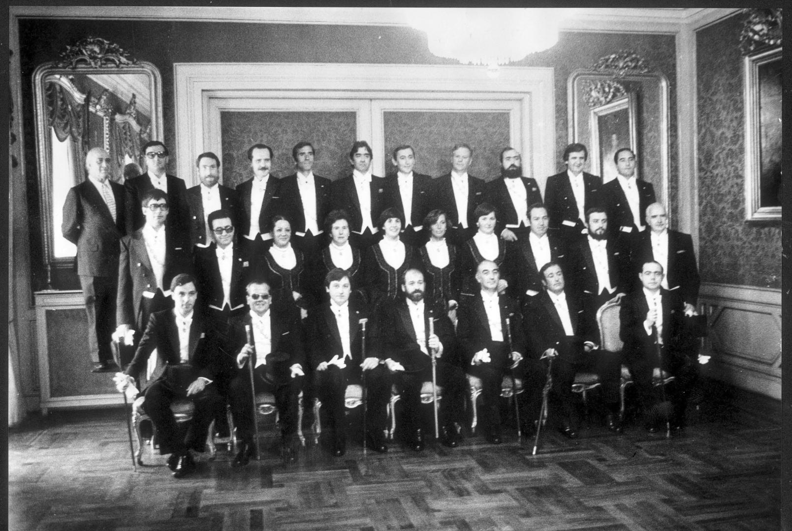 La corporación del Ayuntamiento de Pamplona, en gala en los Sanfermines de 1979. De izquierda a derecha, en la fila superior, Julio Senador (secretario, aunque en el momento de la constitución del Ayuntamiento el cargo lo ocupaba José María San Martín Sánchez), José Luis Garicano Aznárez(UPN), José Luis Napal Chueca (HB), Juan José Araujo Múgica (UCD),Julio Oteiza Huici (PNV), Pedro José Istúriz Izco (PNV), Alfredo Jaime Irujo (UCD), Benicio Aguerrea Zubiri (UPN), Juan Elías Antón Murguiondo (HB), Federico Pérez Soria (UCD) y José Ignacio Beorlegui Recalde (HB). En la fila del medio, Bernabé Alvarez Urroz (PSOE), Pablo García Tellechea (UCD), María Ángeles Oyaga Jimeno (UCD), Mercedes Labayen Arrue (UPN, sustituyó a AlbitoViguria Caparroso), Camino Oslé Guerendiáin (PSOE), Elisa Chacartegui Sánchez, Camino Monasterio Urquía (HB), Francisco Javier Mateo (UPN), Jesús María Andión  y José Luis Rodríguez Pedraza; sentados, Javier Taberna, Juan Manuel Pérez Balda, Patxi Zabaleta, Julián Balduz Calvo, Alfonso Bañón, Miguel González Fontana y Iosu Ostériz.