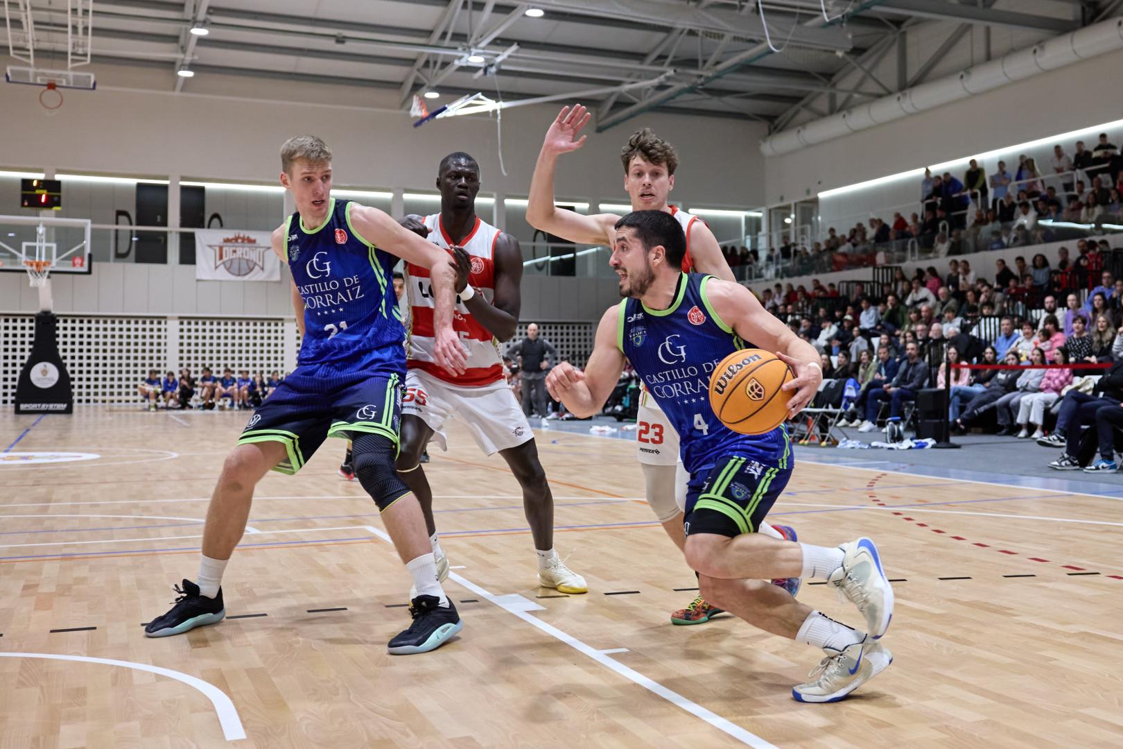 Alex Calvo con el balón frente a un rival de Logrobasket.