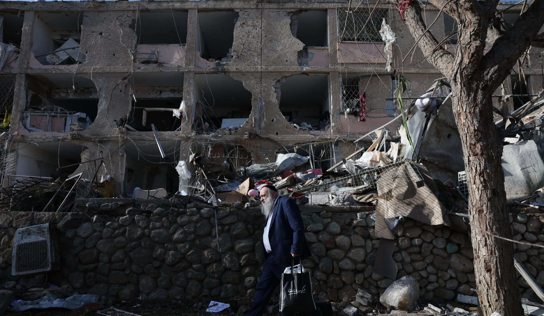 Un hombre pasa por delante de un edificio dañado por el ataque contra Dimona, Israel