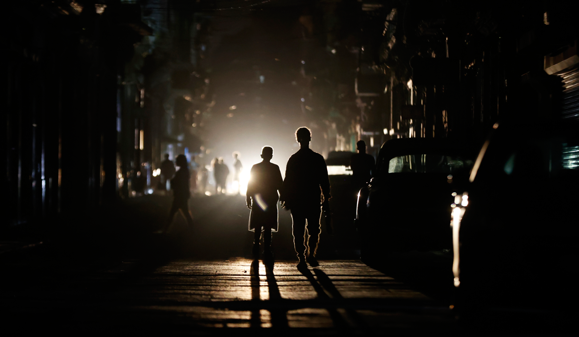 Personas caminan por una calle sin electricidad este sábado, en La Habana (Cuba)