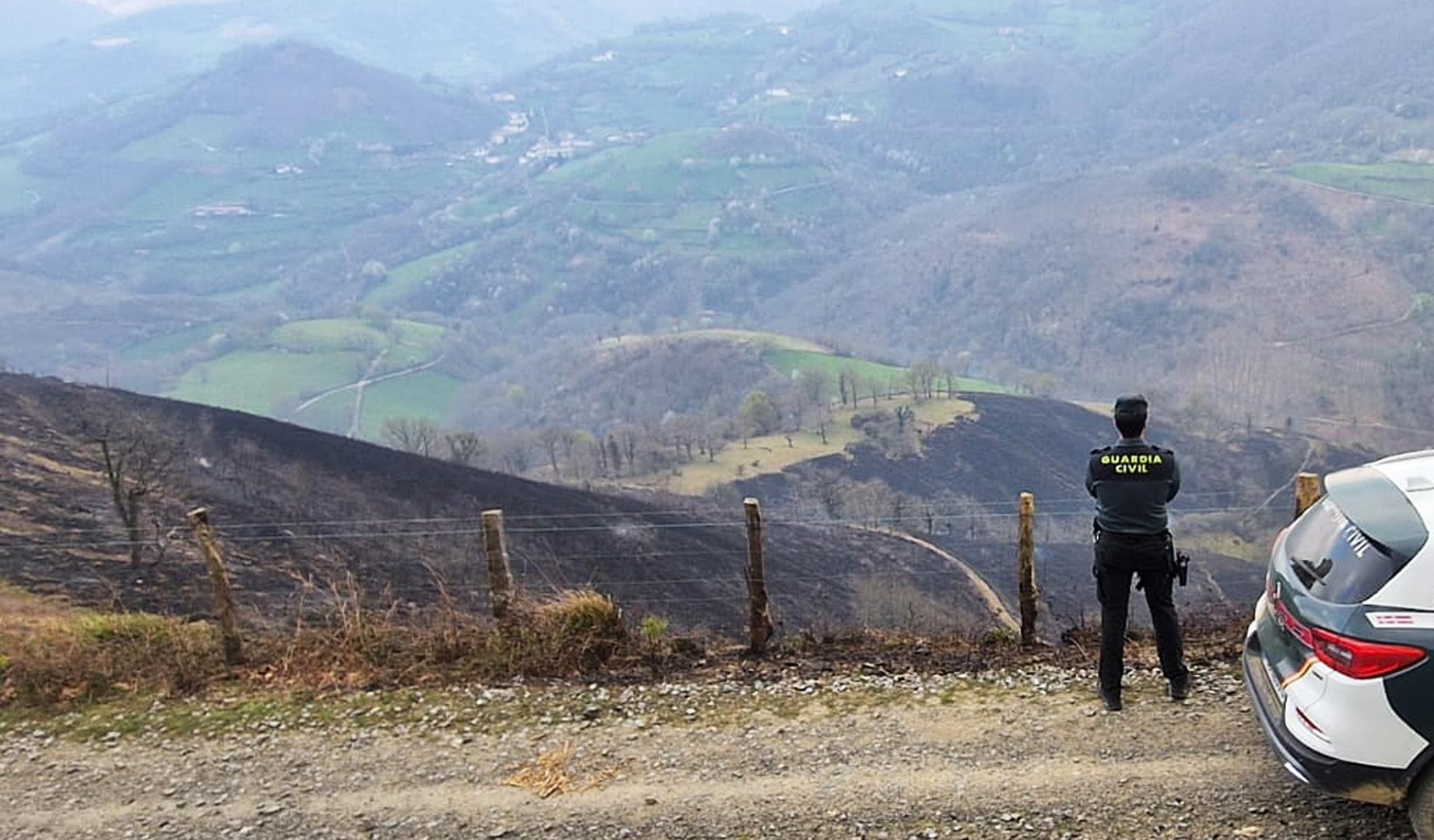 Un agente de la Guardia Civil junto a la zona afectada por el incendio