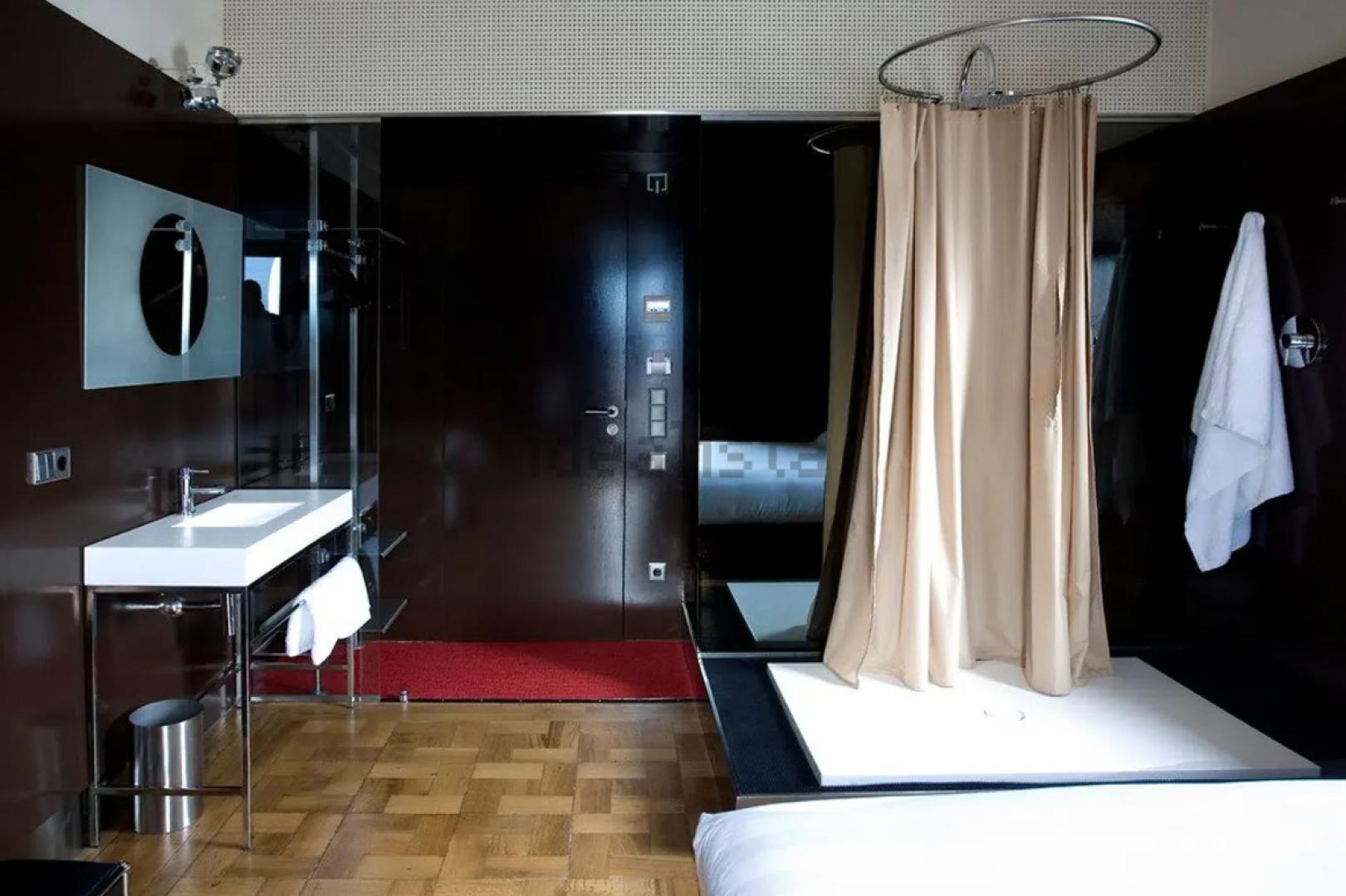 Habitación con ducha junto a la cama