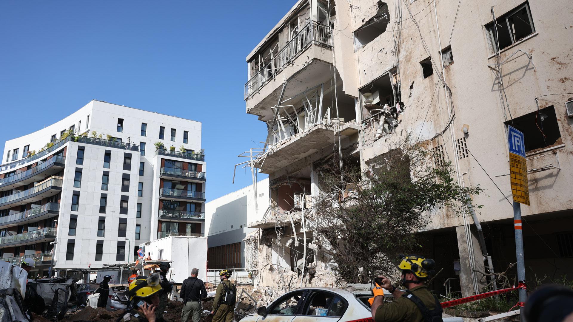 Equipos de emergencia israelíes trabajan en el lugar de un ataque con misiles iraníes en una zona residencial de Tel Aviv