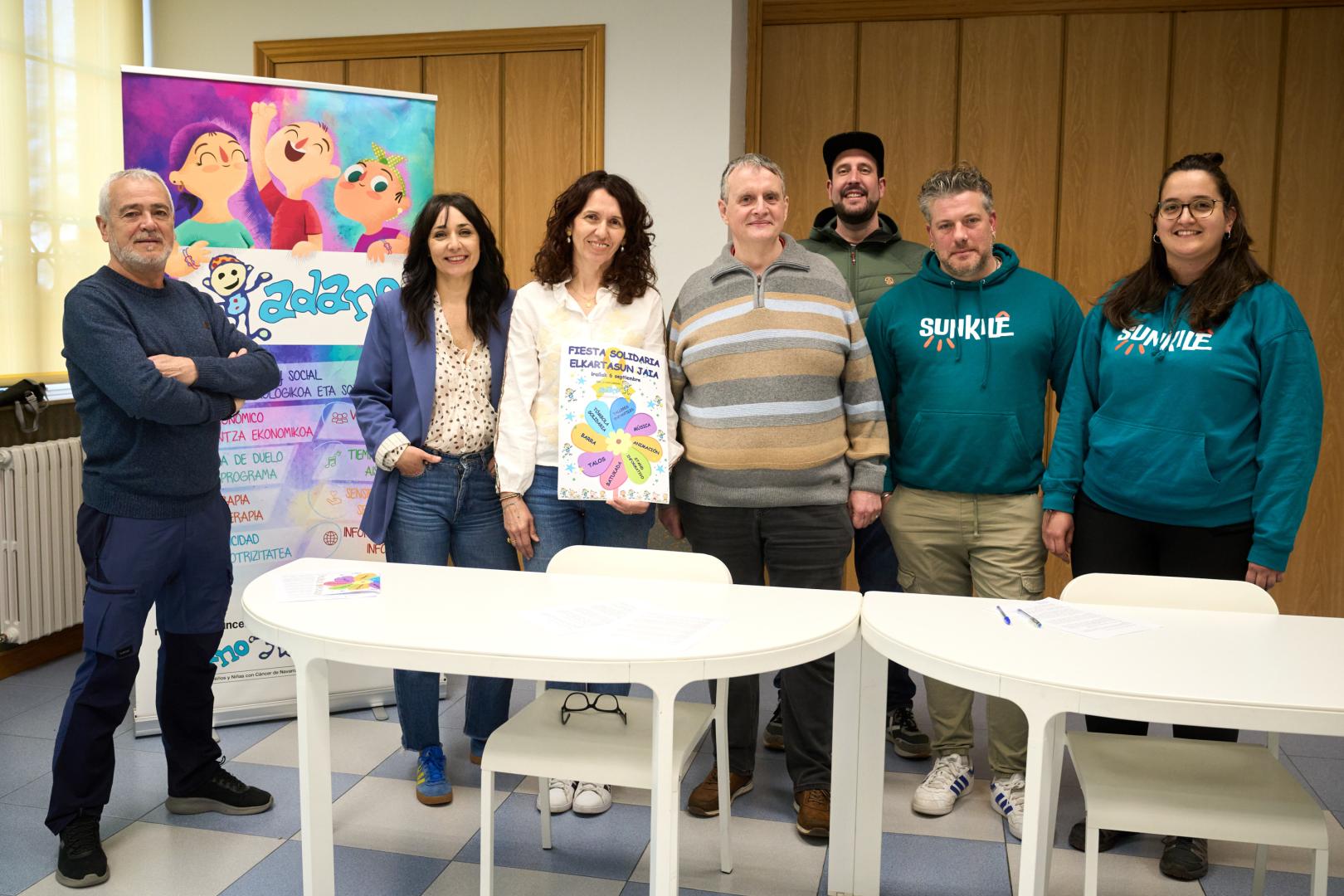 Luis Vila (Berriozar), Izaskun Larumbe Y Cristina Delgado (ADANO), David Artuch (Tenampas), Jokin Ventosa (junta de ADANO), Iván Martín y Leyre Meléndez (Batukada Sunkile), durante la presentación de la III Fiesta Solidaria de ADANO