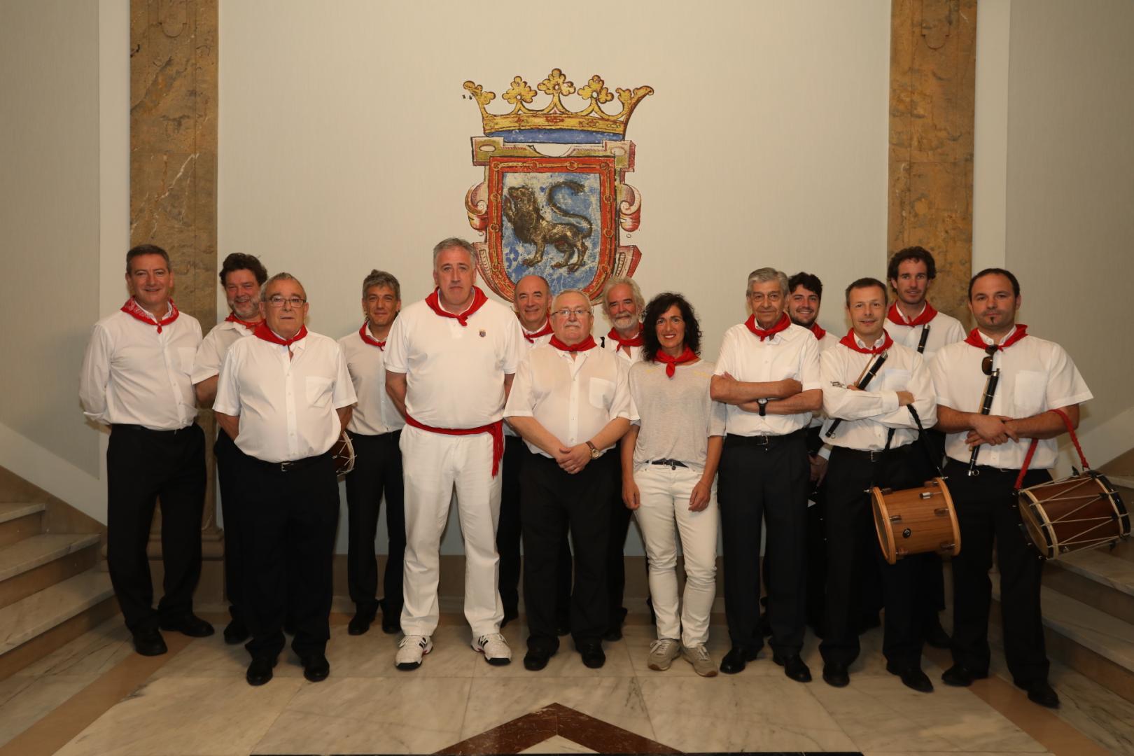 Foto de familia con el homenajeado en el centro, entre el alcalde de Pamplona y la alcaldesa de Tolosa.
