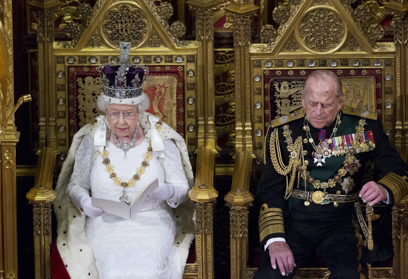 Imagen de archivo fechada el 18 de mayo de 2016 que muestra a la reina Isabel II y al príncipe Felipe de Edimburgo durante la ceremonia de apertura del Parlamento en la Cámara de los Lores en Londres