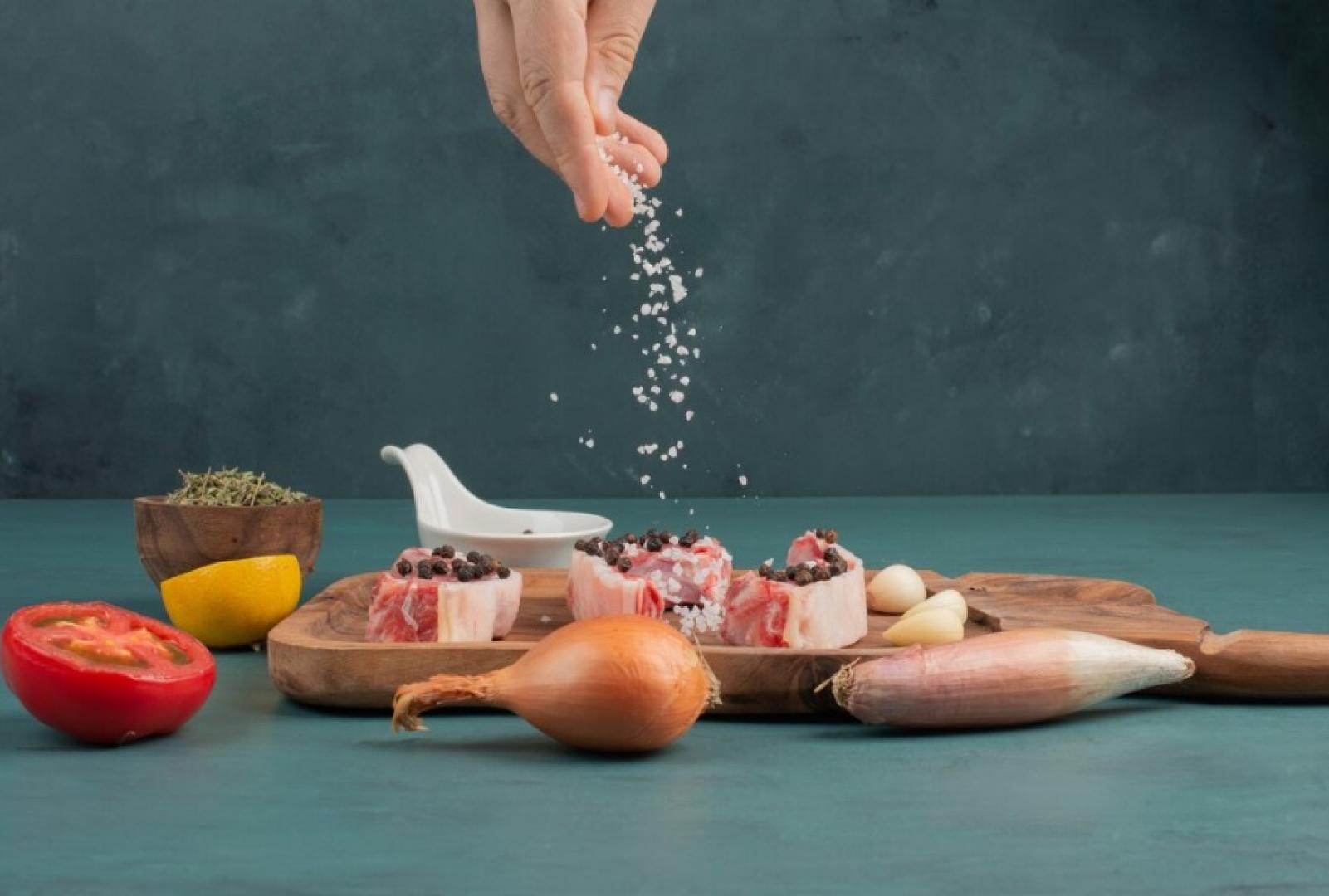 Condimenta con sal pedazos de carne