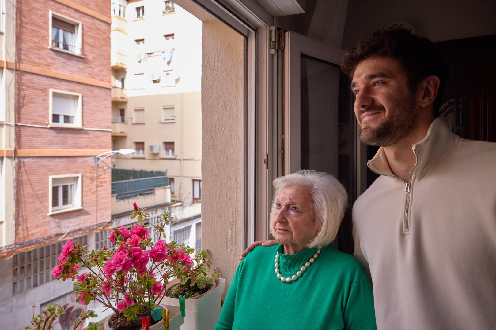 María Luisa Martínez y su nieto mayor, Miguel Alfaro, observan la calle Joaquín Larregla de La Milagrosa desde la ventana de ella