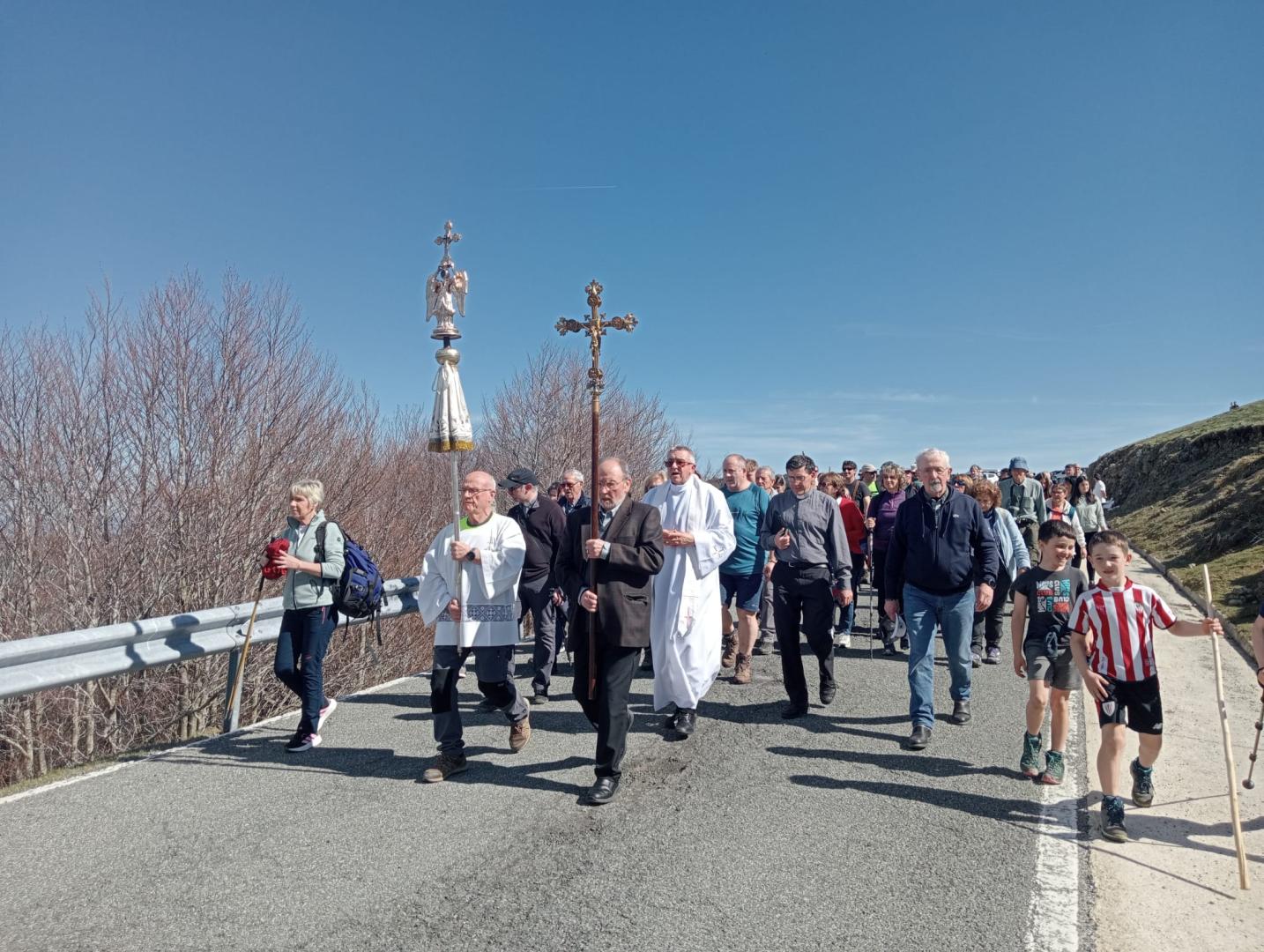 La efigie del Ángel de Aralar y la cruz del santuario nada más iniciar el camino. Tras ellas, el capellán, Alfonso Garciandía.