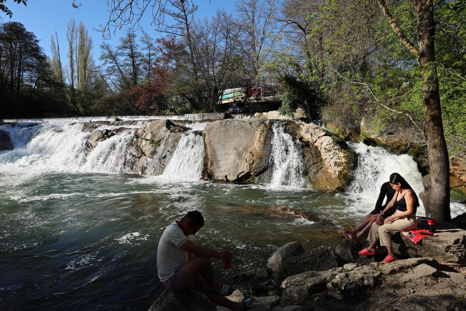 Tres personas se refrescan en la presa de Huarte e estos días de calor.