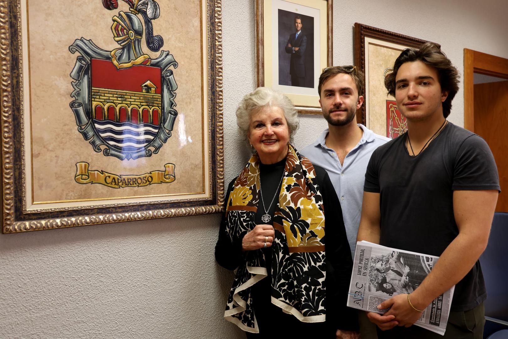 Mª Pilar Galindo López Portillo, con sus nietos Jaime y Pedro, en el salón de plenos, con el escudo de Caparroso. Al fondo, la imagen de Felipe VI