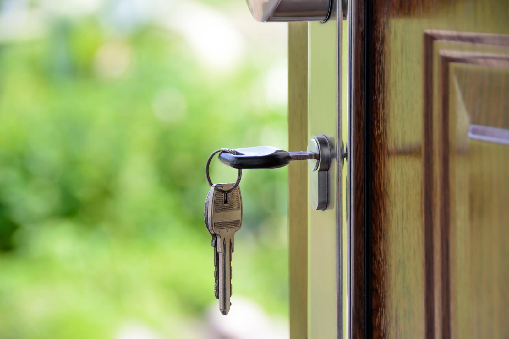 Keys and lock the door on the background of solar garden Keys to your own homeLLAVES PUESTAS EN UNA PUERTA.