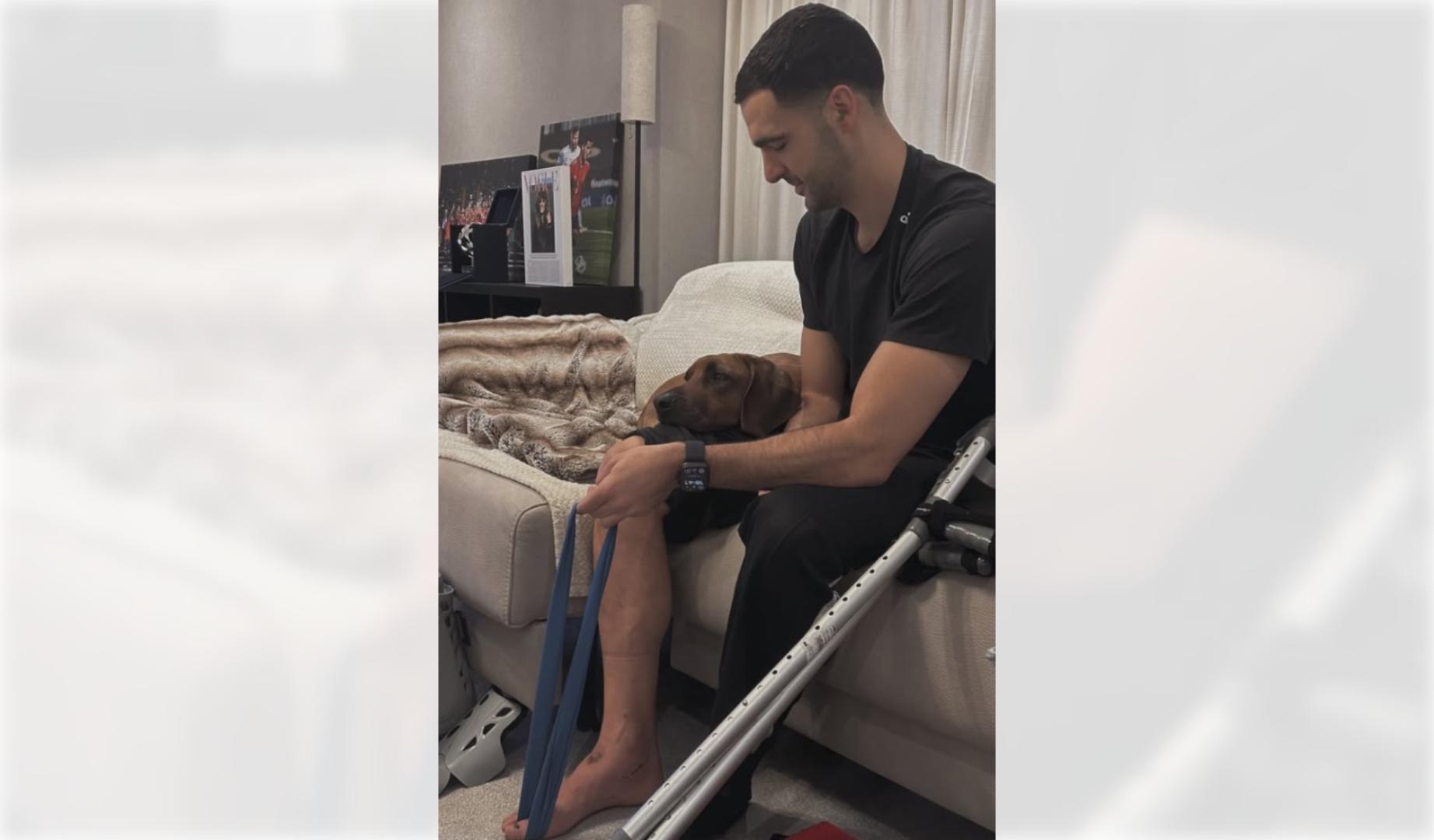 Mikel Merino realiza ejercicios en su domicilio junto a su perro tras ser operado del pie
