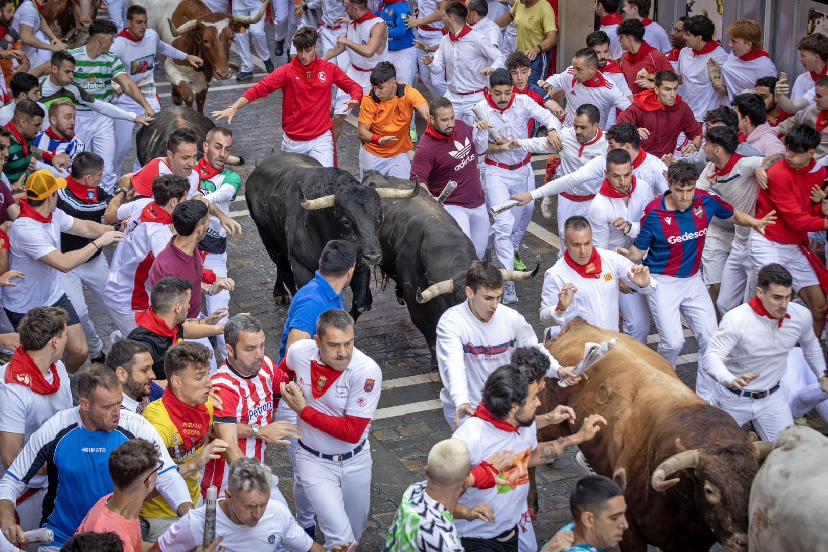 Pablo Alfaro en medio de la imagen y con periódico en mano en el séptimo encierro de San Fermín 2025