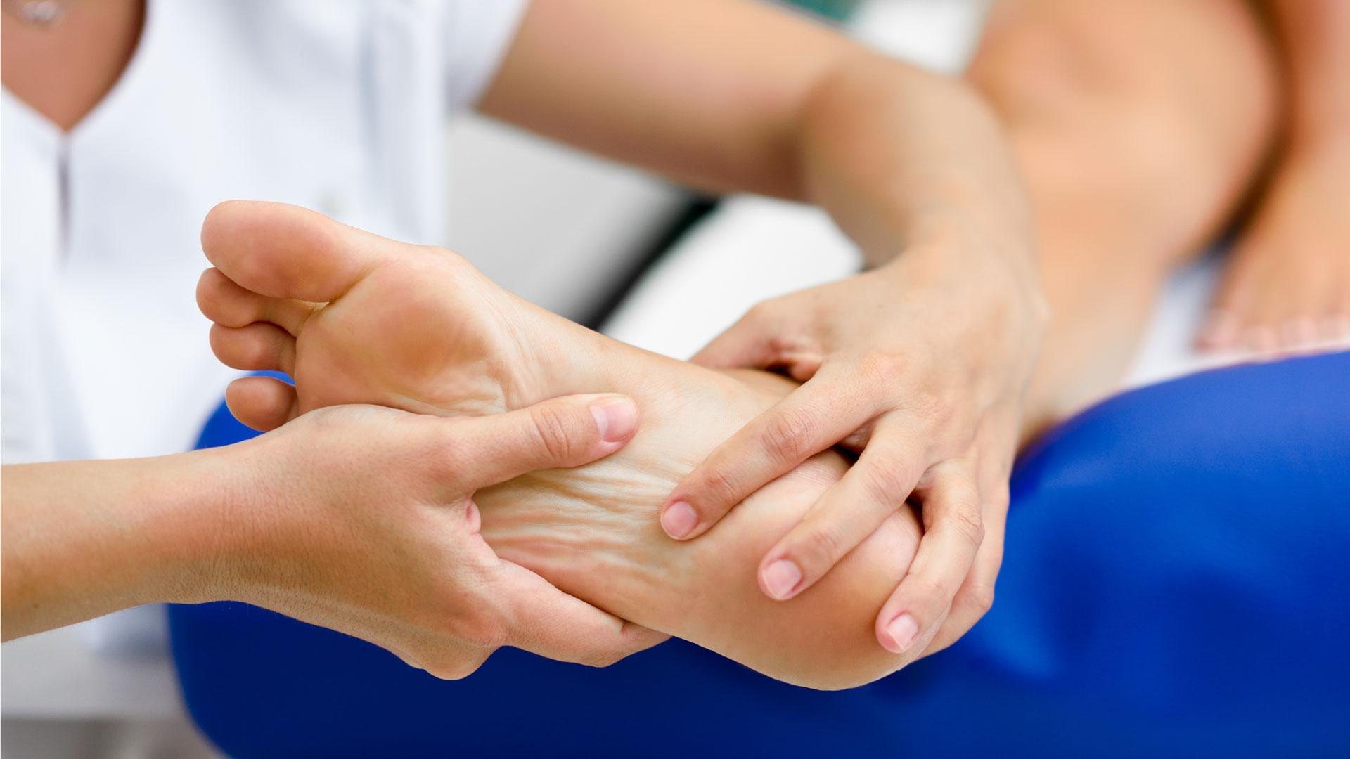 Una fisio trata a un paciente de espolón calcáneo, un crecimiento óseo en forma de espina en el hueso del talón