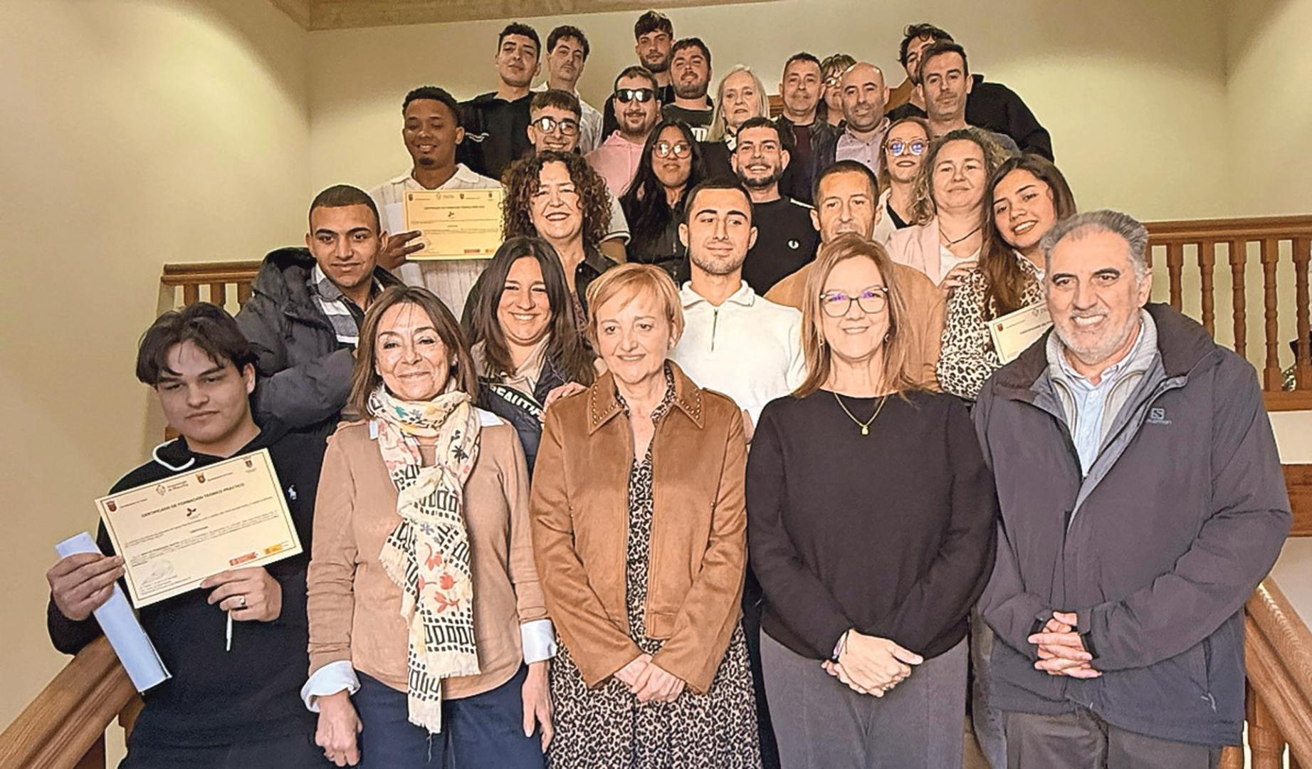El alumnado graduado en la escuela taller con las autoridades que acudieron a la clausura