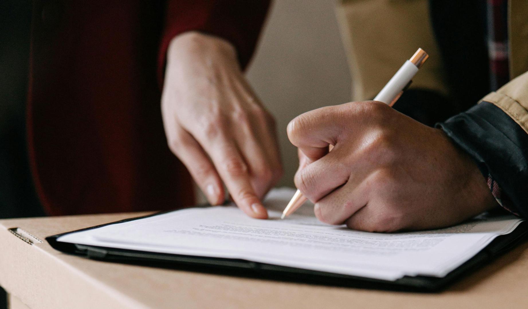 Una persona firmando un documento