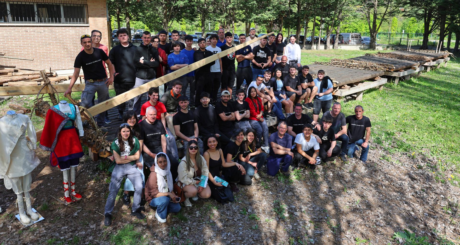 Alumnado, profesorado, almadieros y colaboradores, junto a la almadía que luce en el patio del C.I. Donibane de Pamplona, y el nuevo traje de almadiera