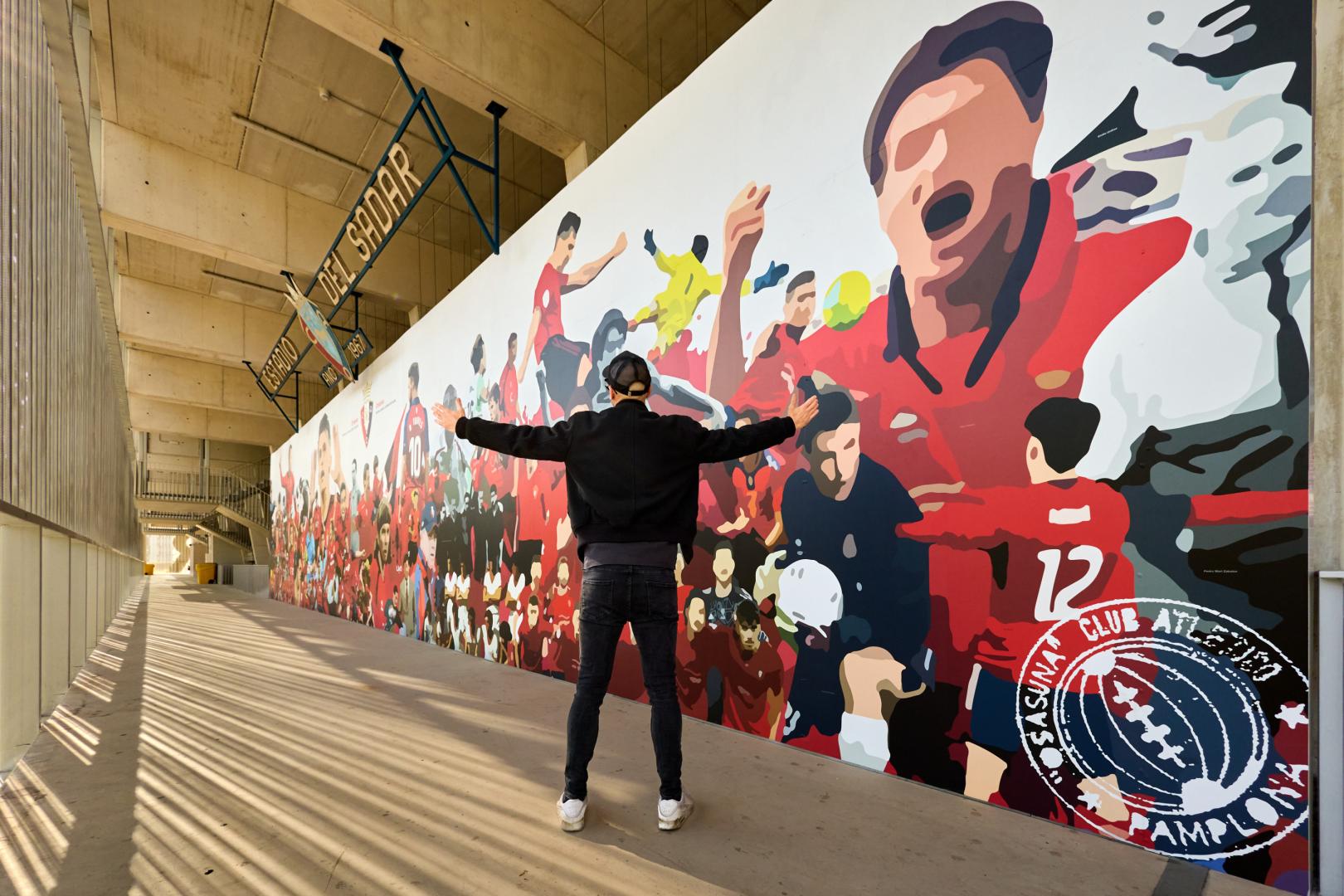 El artista LKN, delante del mural instalado en la zona de grada Lateral de El Sadar.