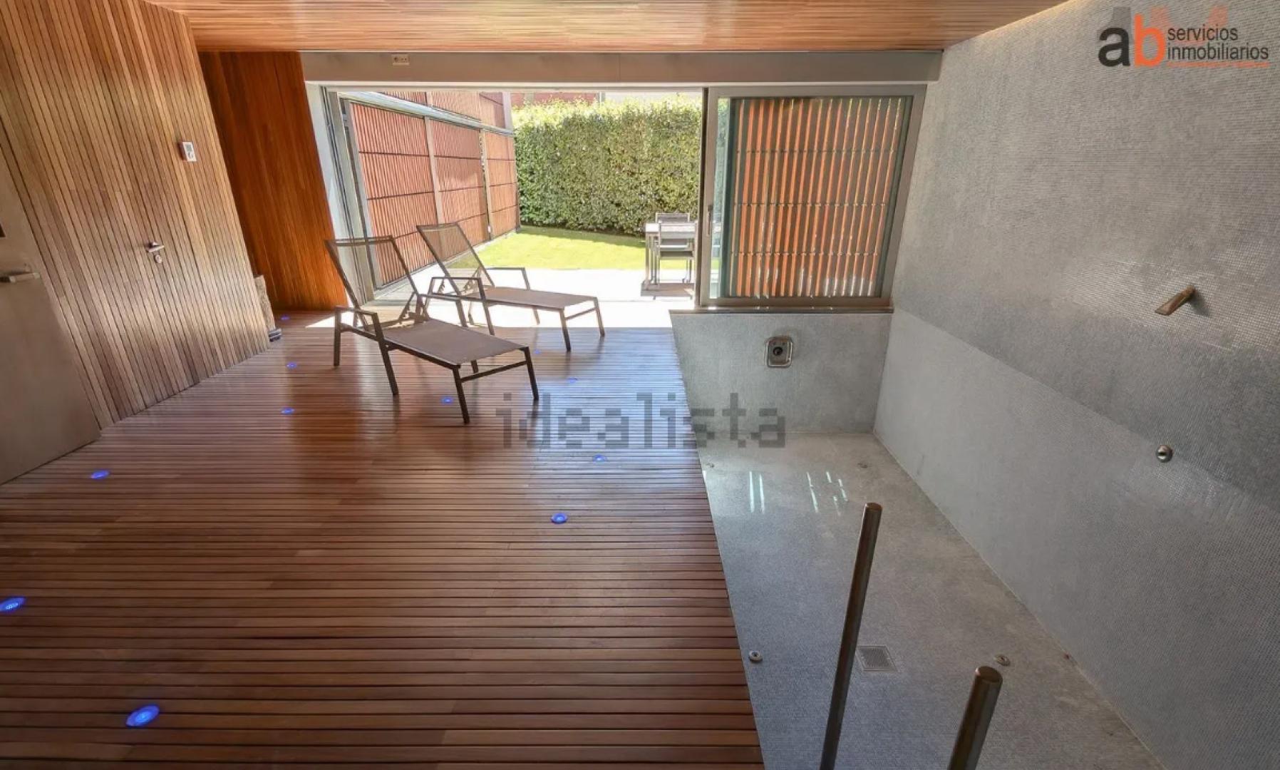 Piscina cubierta que se abre al jardín gracias a unas cristaleras correderas