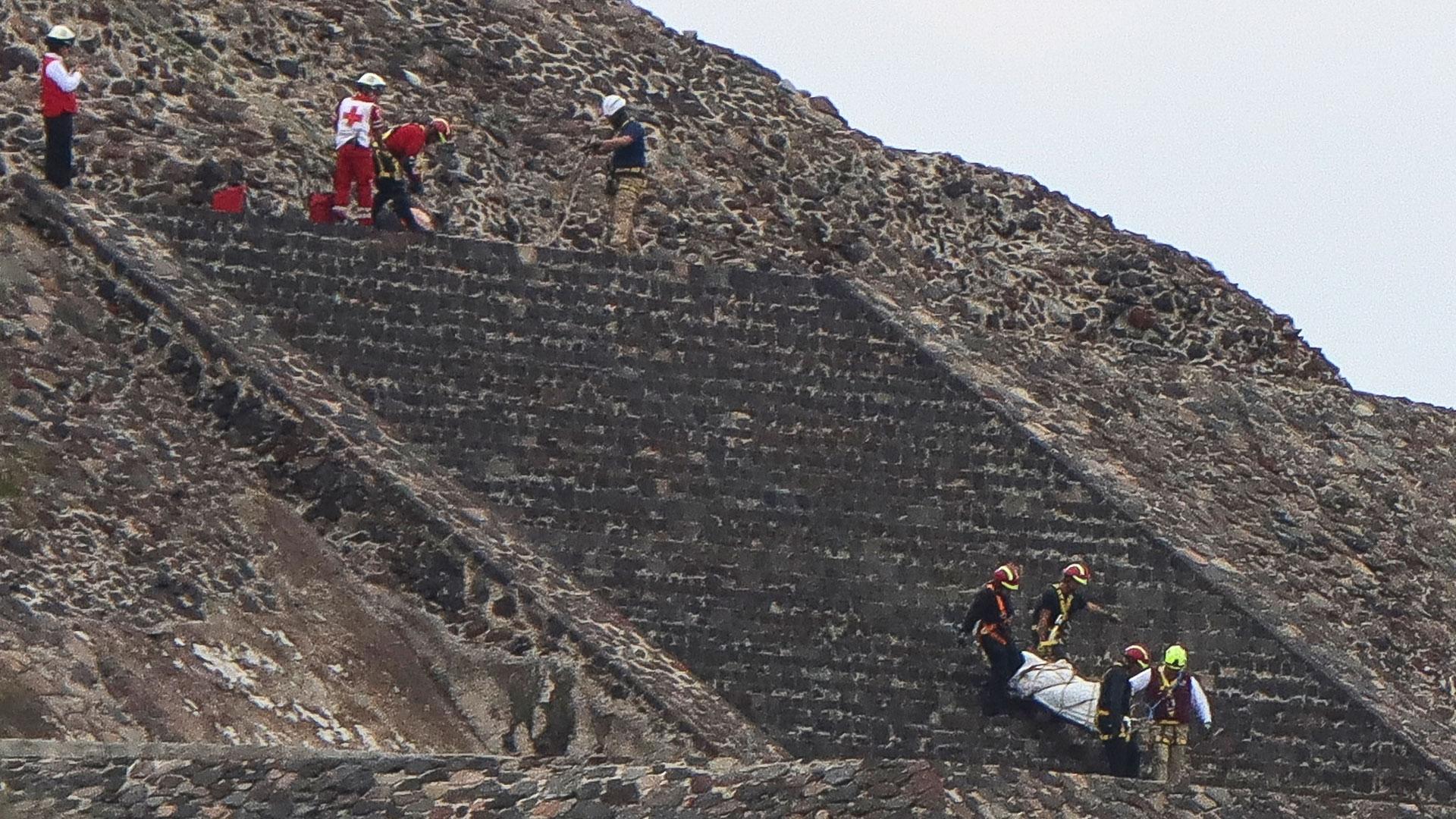 Integrantes de la policía mexicana y peritos forenses trabajan en la pirámide en la que se registró un tiroteo este lunes, en la zona arqueológica de Teotihuacán