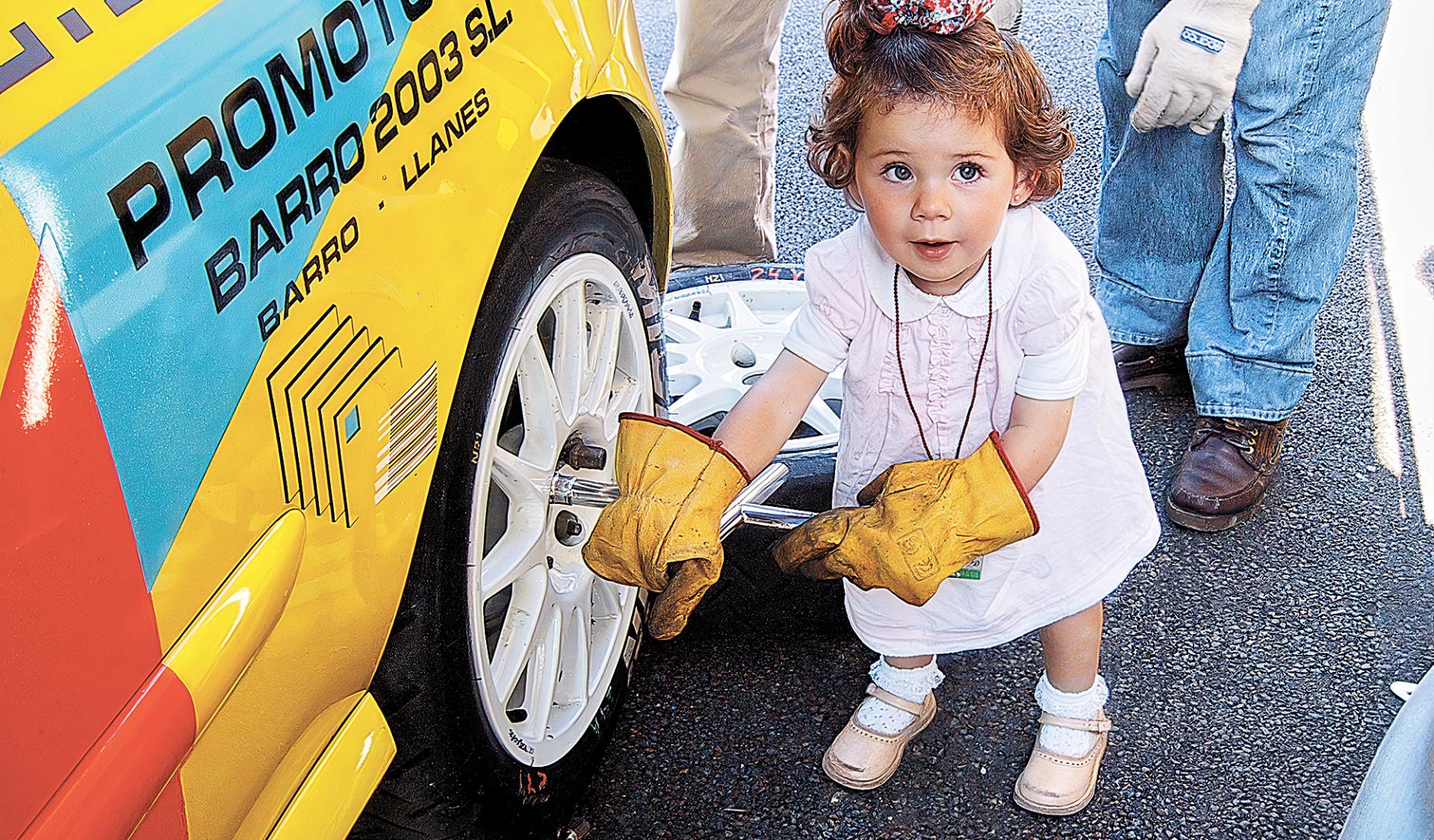 Marina, de pequeña, emulando un cambio de ruedas en el coche