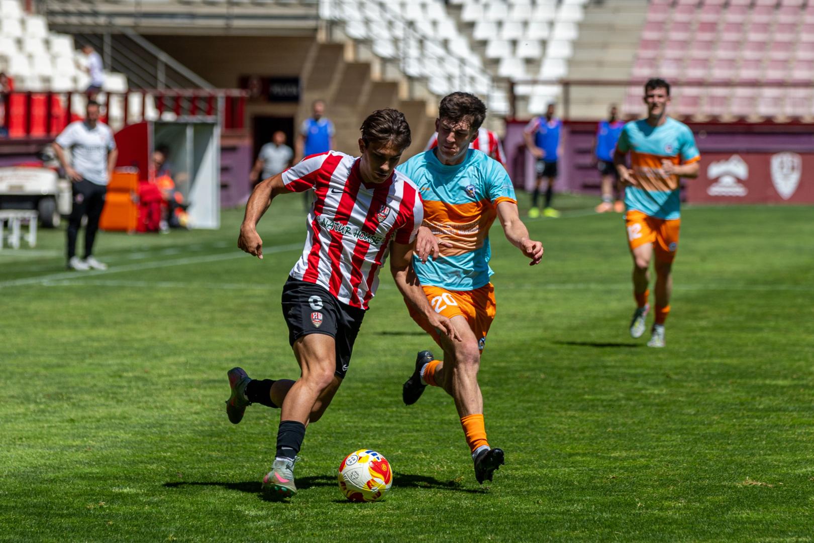 Albert Rosas, de la U.D.Logroñés, conduce el balón ante la presión de Xabier Roldán, de la Mutilvera