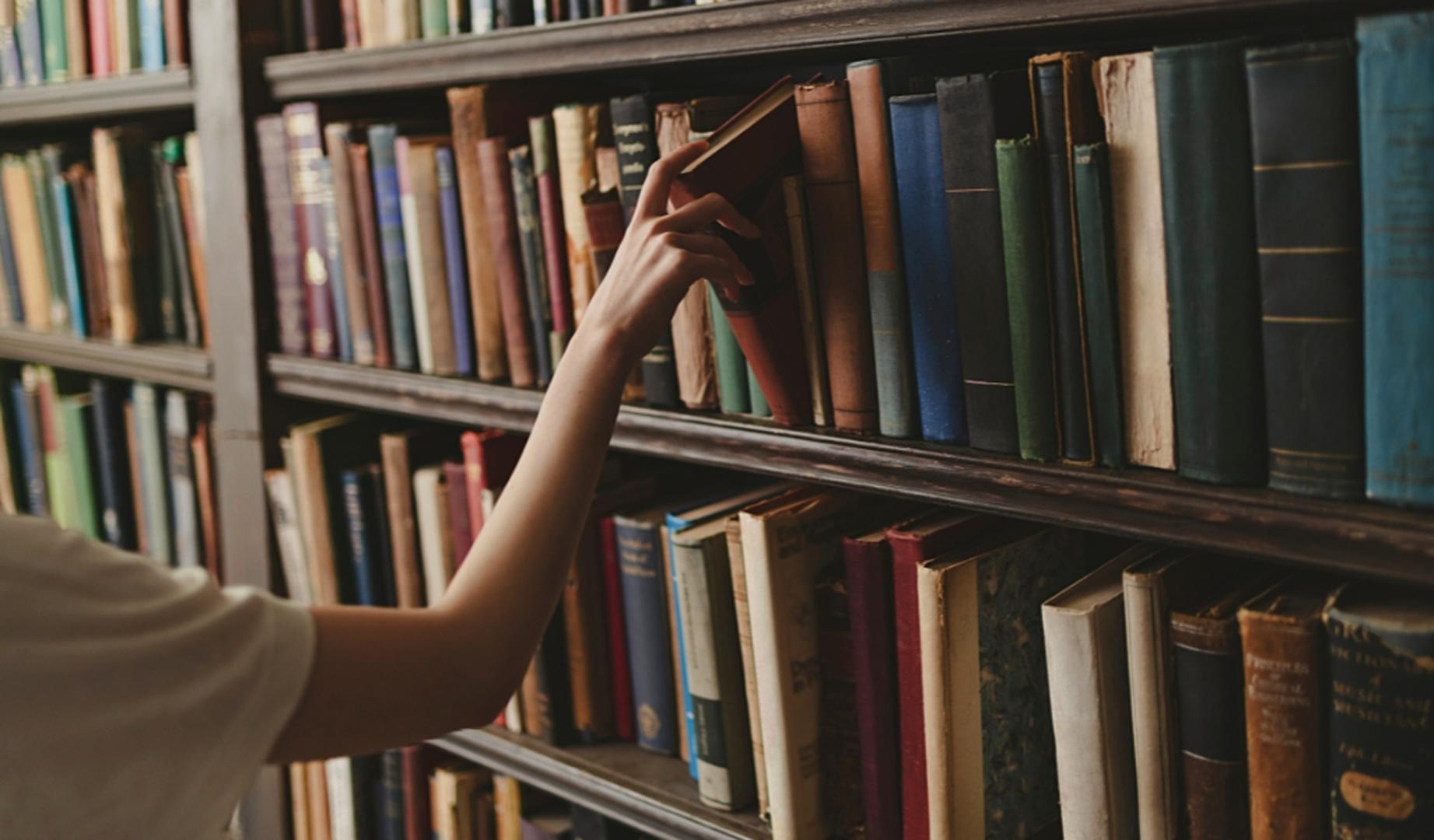 Una persona extrae un ejemplar de una librería