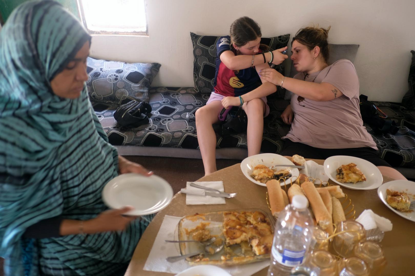 Lala, en primer plano, reparte la comida que ha preparado. Atrás, Laura ayuda a pincharse a Helena.