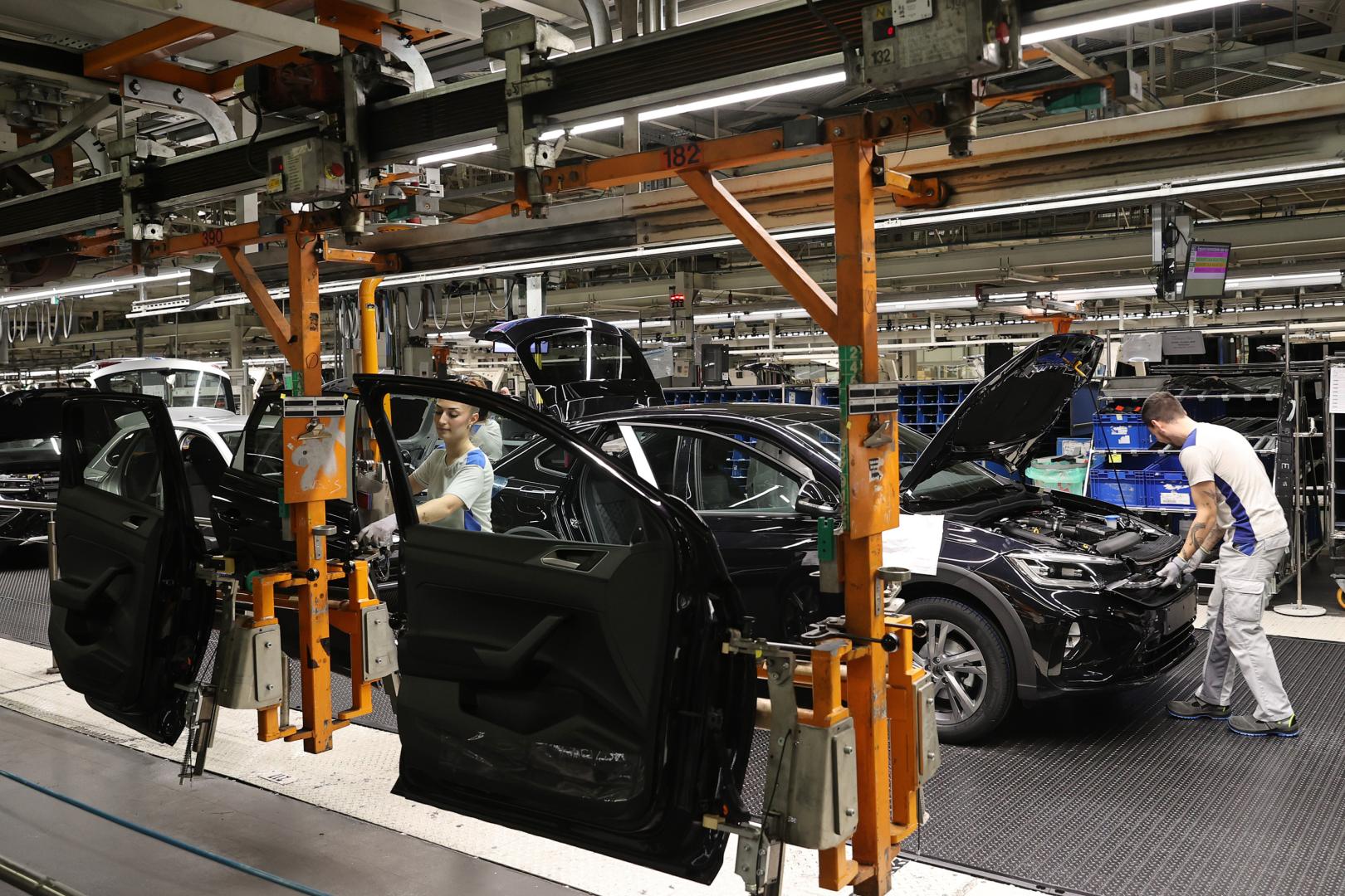 Operarios del taller de montaje en la fase de colocación de las puertas de uno de los coches
