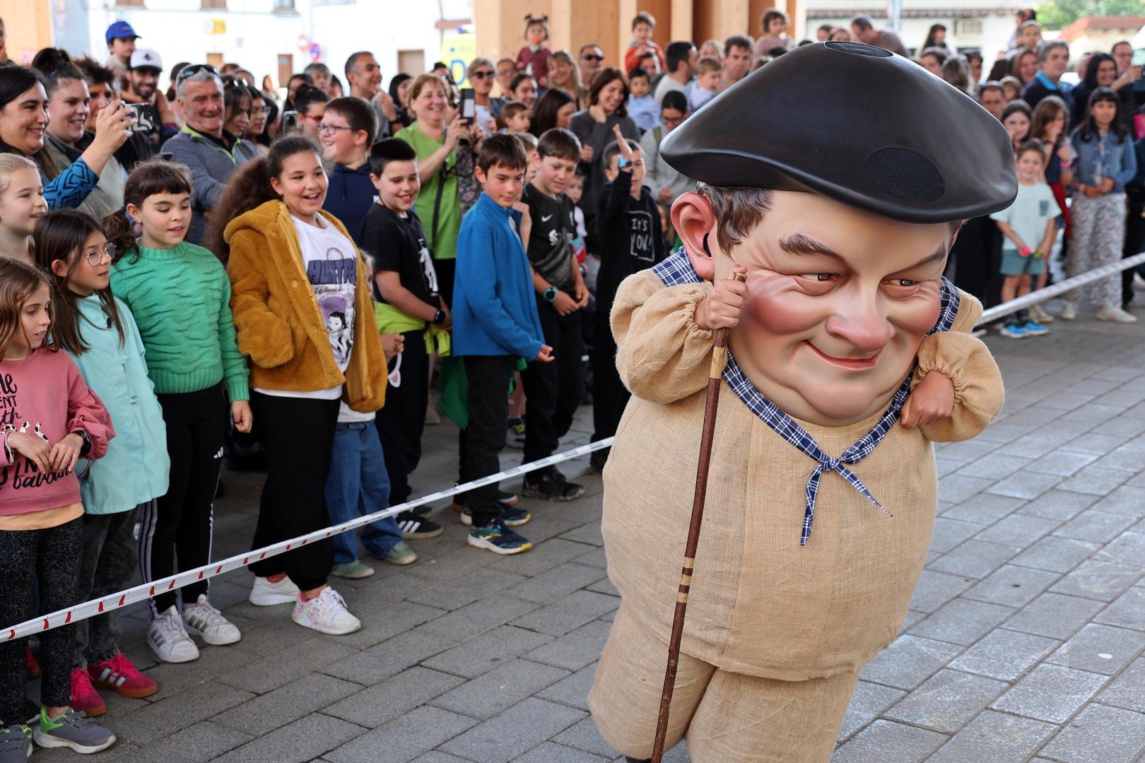 El cabezudo 'Juantramposo' pasa por delante de un grupo de menores durante su presentación.