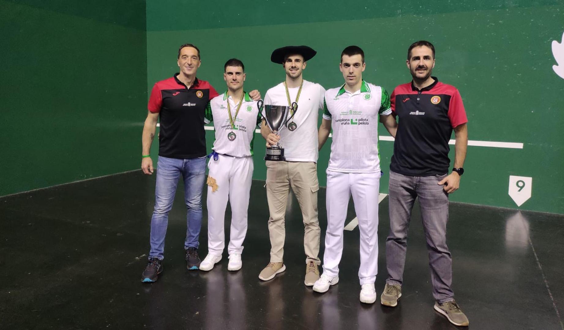 EL HOMBRE CLAVE. Fermín Arribillaga, mano individual sénior, sostiene el trofeo de campeones del GRABNI con sus compañeros