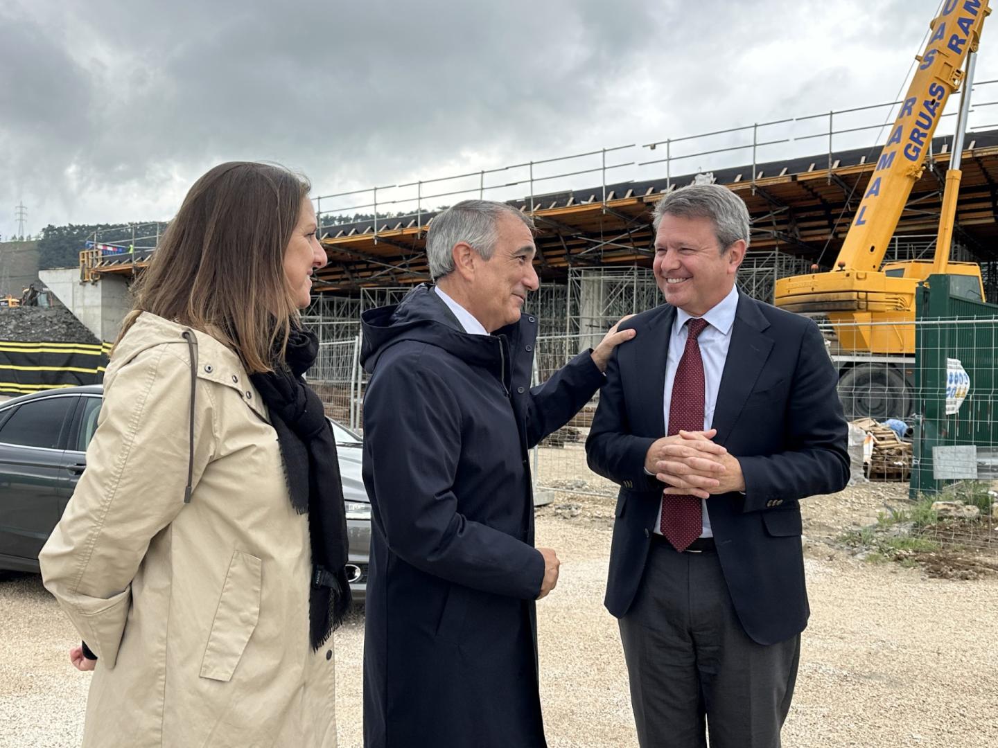 La directora general de Obras Públicas e Infraestructuras, María Torres; el consejero de Cohesión Territorial del Gobierno navarro, Óscar Chivite, y el secretario de Estado de Transportes, José Antonio Santano, junto a las obras de construcción de uno de los dos puentes de acceso a los polígonos