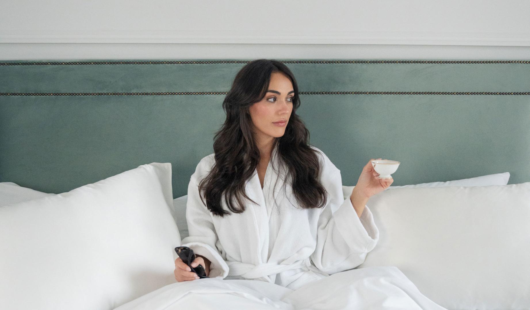La pamplonesa Ana de Miguel posa en una cama con varias fundas de almohadas de seda que vende a través de su negocio digital Onisa Coté